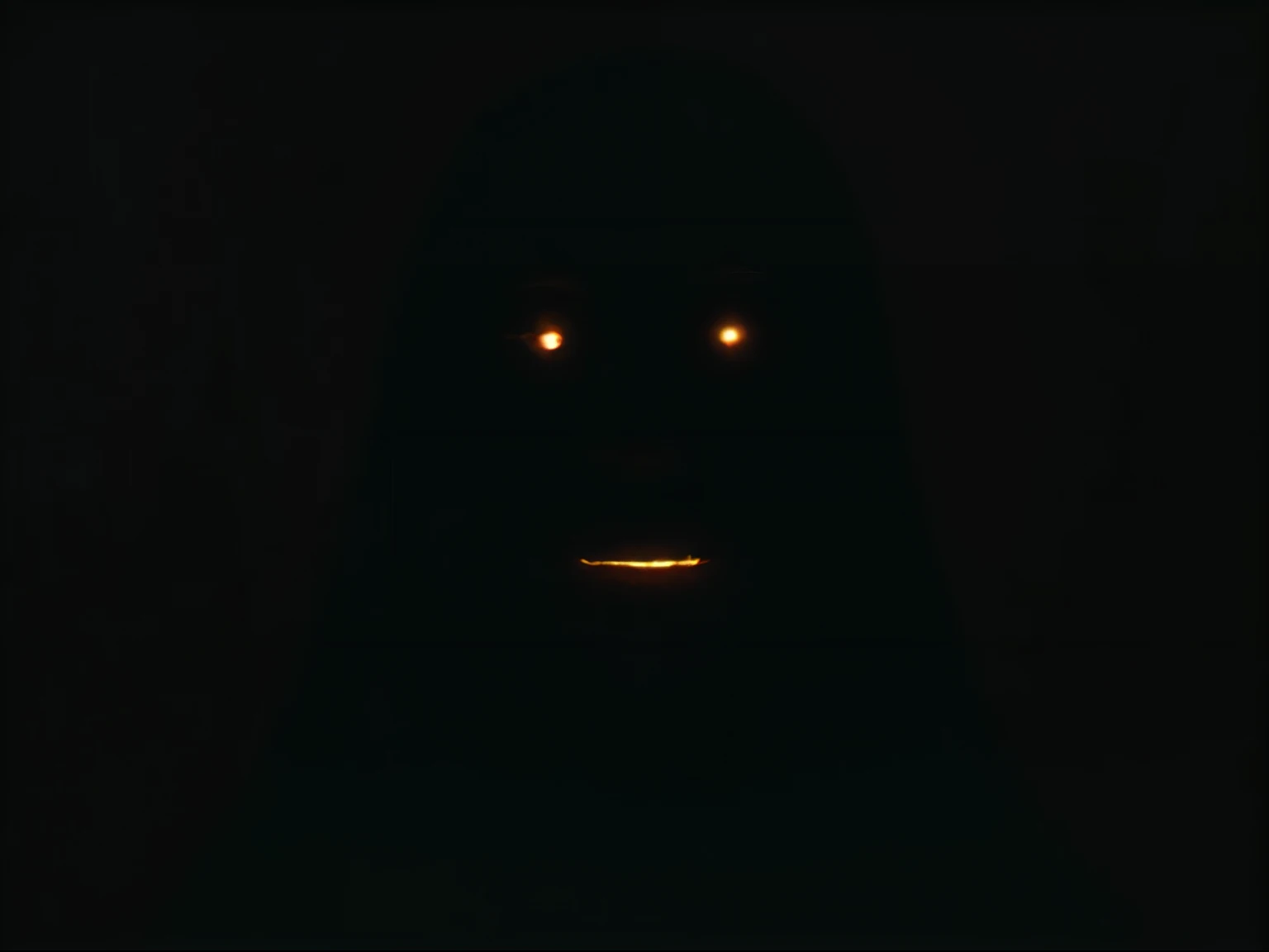 A face in the darkness you can't really see, only the white glowing eyes and the mouth that hangs completely open