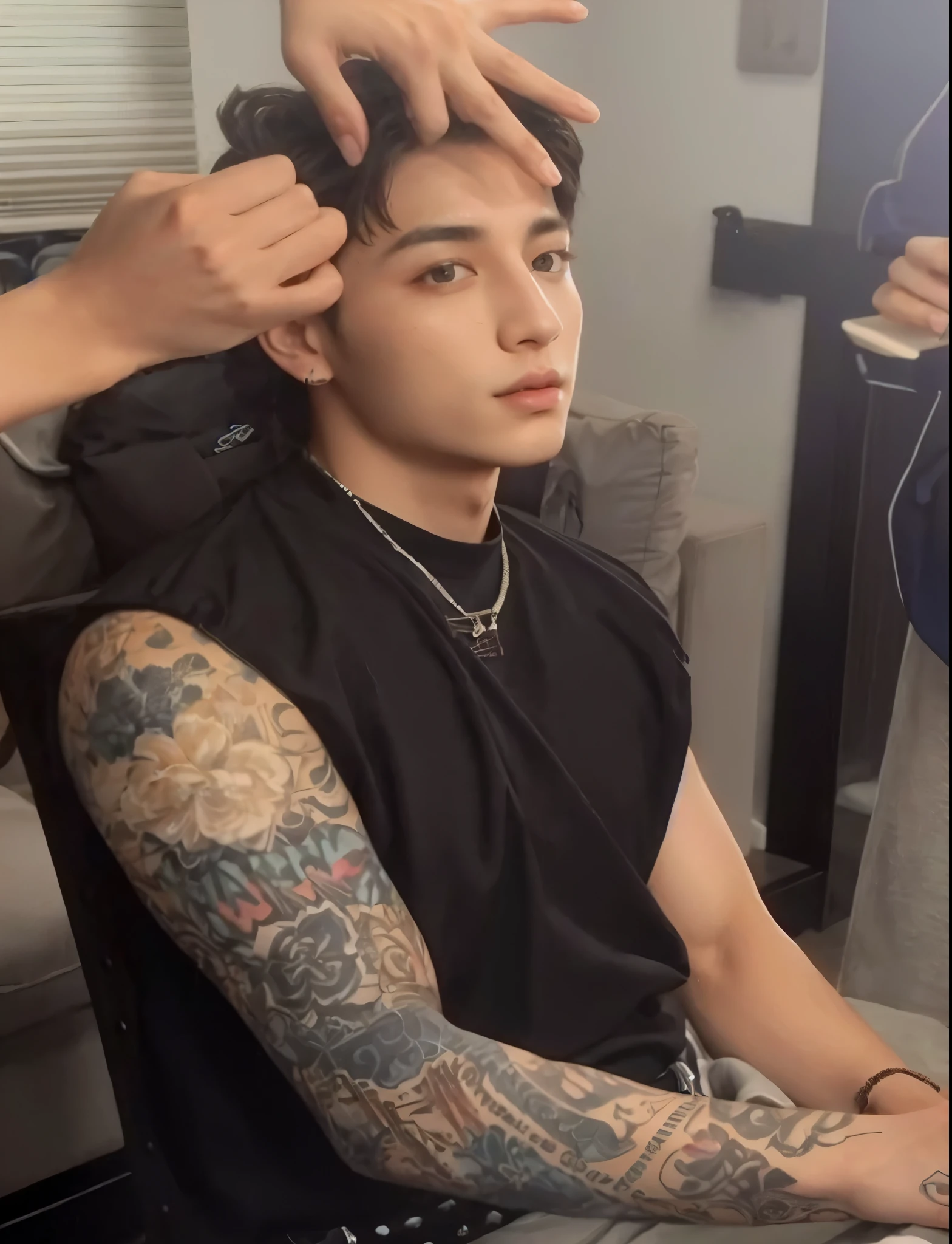 homem arafiado com tatuagens sentado em uma cadeira enquanto uma mulher penteia seu cabelo, Kim jungkook, hyung kook , jungkook kim, com o mesmo penteado, Jungkook, xqc, he has an elongated head shape, adorable and pale korean face, Jeon jungkook, ele tem cabelos grisalhos escuros, ele tem um brilho vindo dele, looking defiantly at the camera
