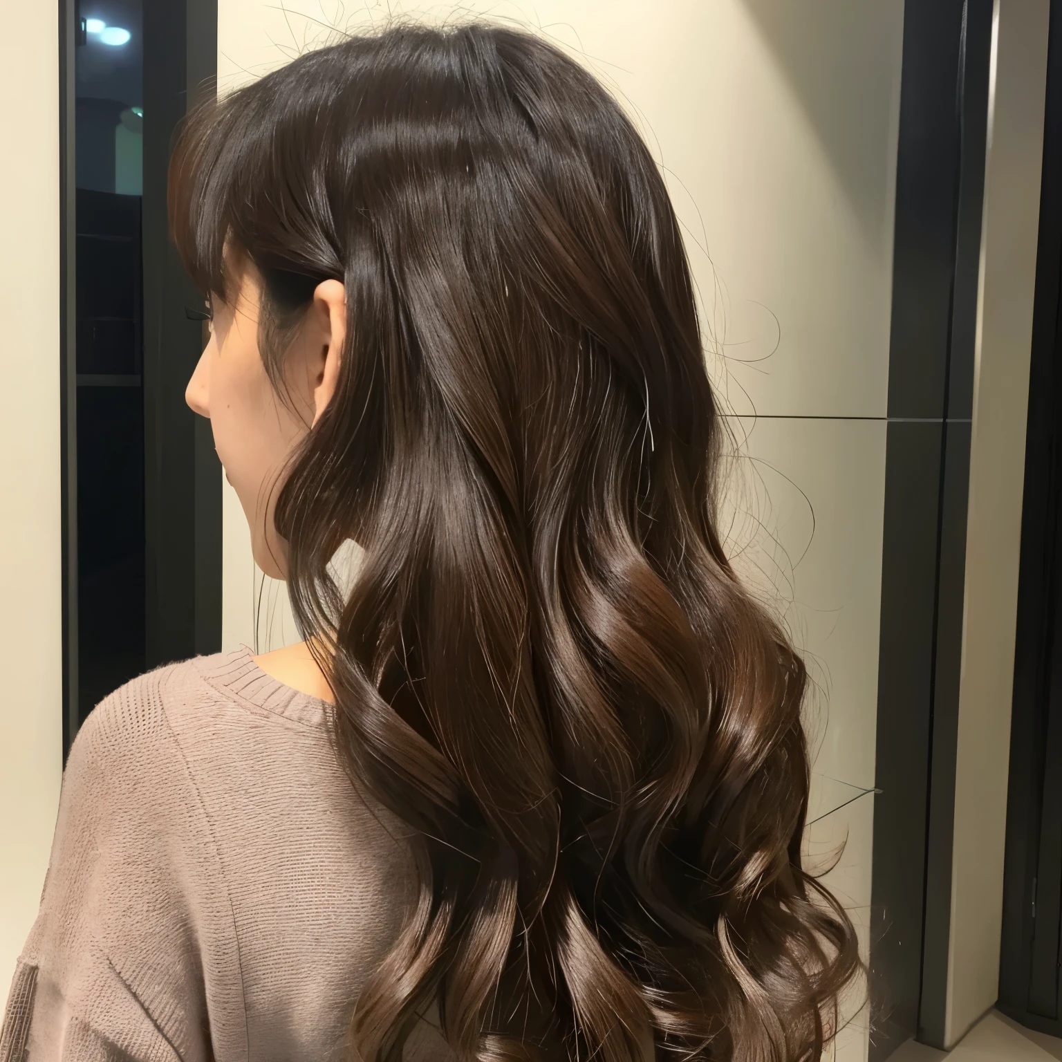 Back view of a woman with long hair。hair color is dark brown。Loose wavy hair。