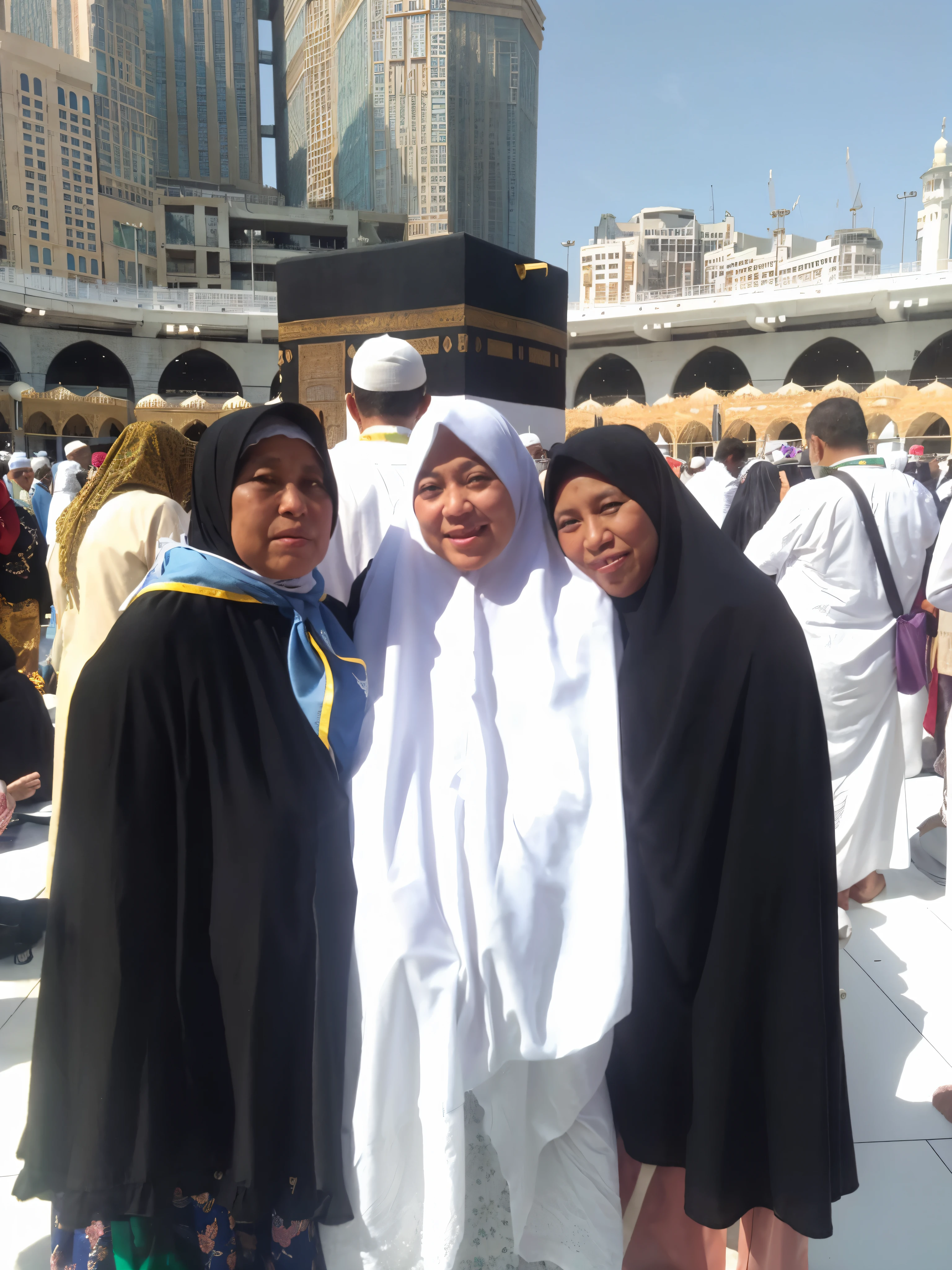 3 older woman standing in fromt of the kabba, wearing syari hijab long gown