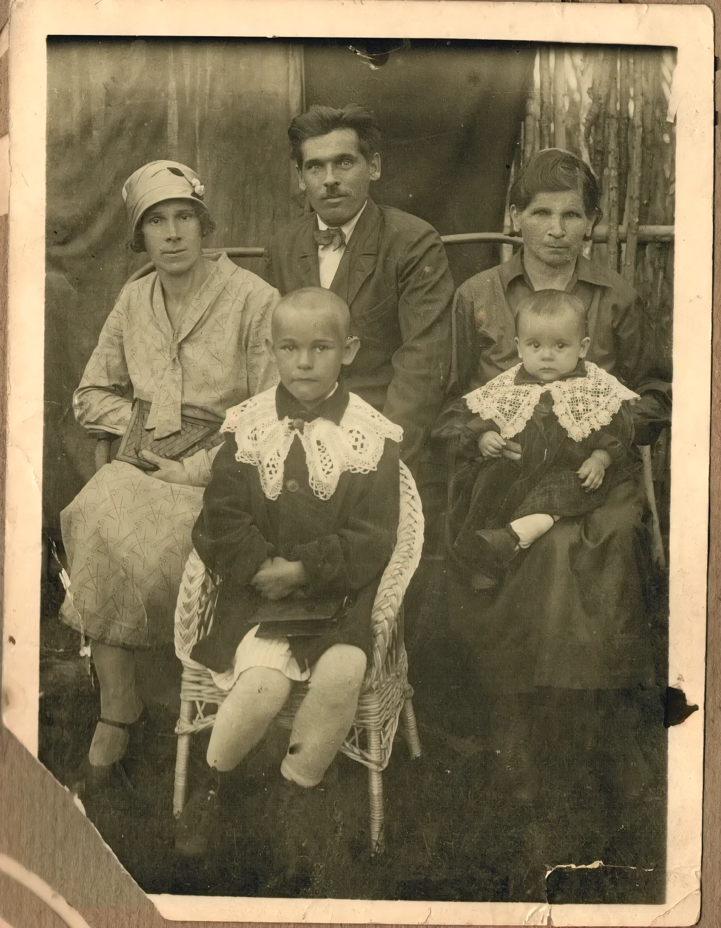 an Old photo of a family sitting in a chair together, Old photo, very Old photo, Old photo, 1 9 2 0 s monochrome shot, old picture, Type of old can, black and white Old photo, unknown place, old vintage photo, Family portrait, vintage Old photo, Vintage Photo, real vintage photo, old black and white photograph, family photo