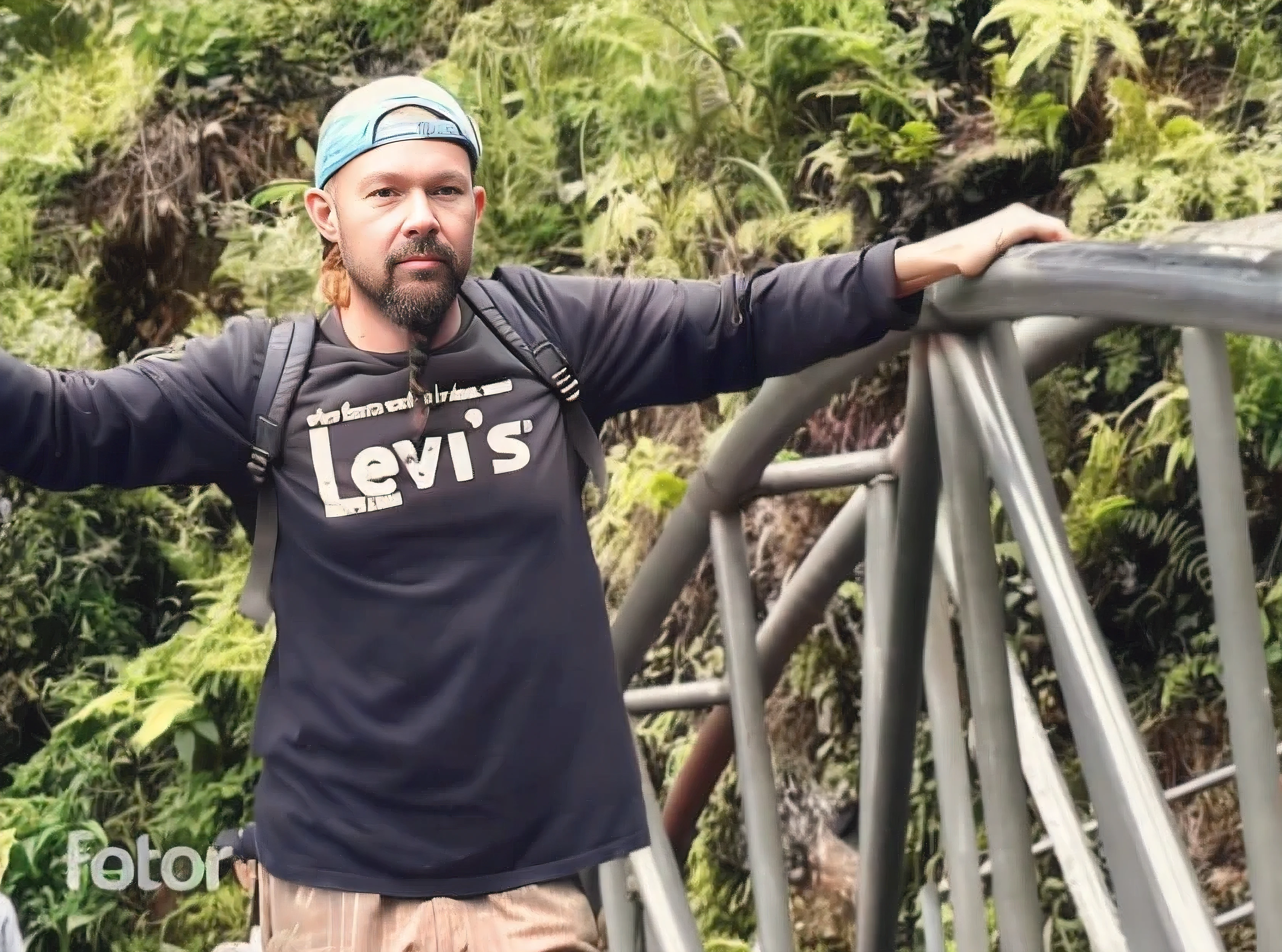 there is a man standing on a bridge with his arms outstretched, wearing adventuring gear, in front of a forest background, 