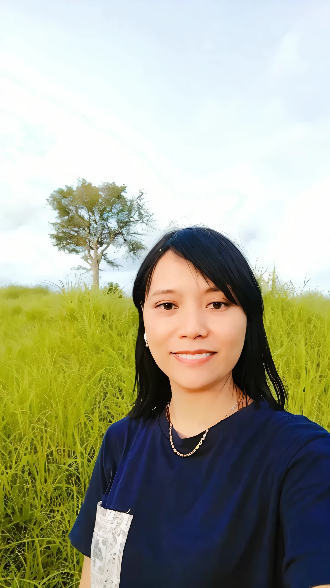 woman in a blue shirt standing in a field of tall grass, in front of a forest background, with a tree in the background, with earth in the background, in a large grassy green field, nivanh chanthara, 8k selfie photograph, in a field, with a park in the background, with sunset, with a tall tree, with trees