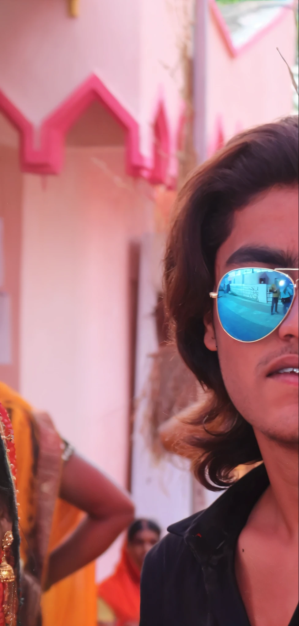 they are posing for a picture in front of a colorful building, with his long black hair, he is a rockstar, with lovely look, candid picture, dressed in a jodhpuri suit, very sharp details, beautiful man, he is wearing a black, actor, in costume, ranjit ghosh, ayan nag, full body shot close up