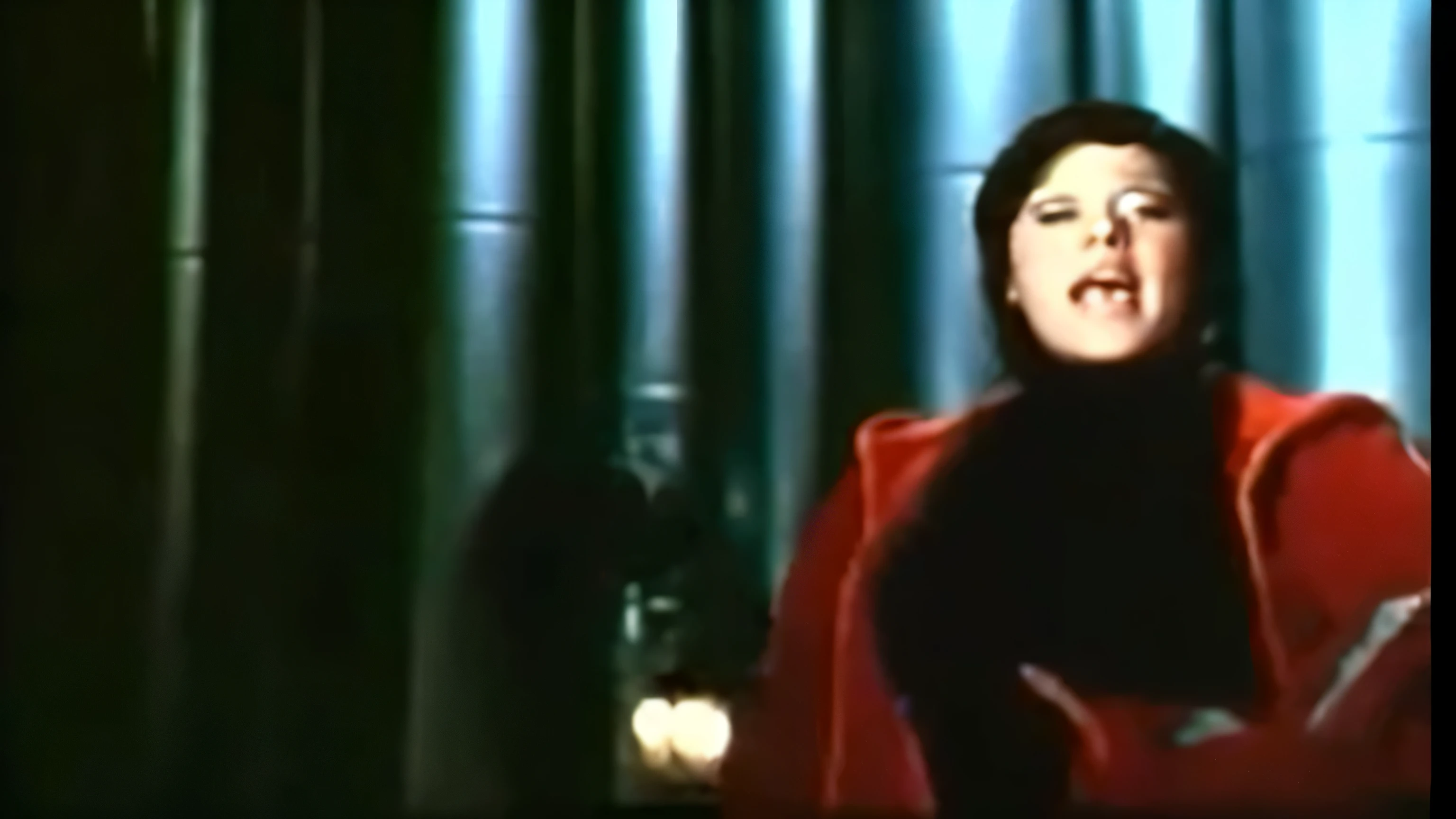 there is a woman singing in a red coat on television, screenshot of youtube video, still from a music video, captura de tela do filme, music video, captura de tela de um filme, captura de pano vhs, captura de tela do filme, Carmen canta lindamente, cena de supplizia, captura de tela do filme, cena de um filme 1 9 7 3, performing a music video, velma