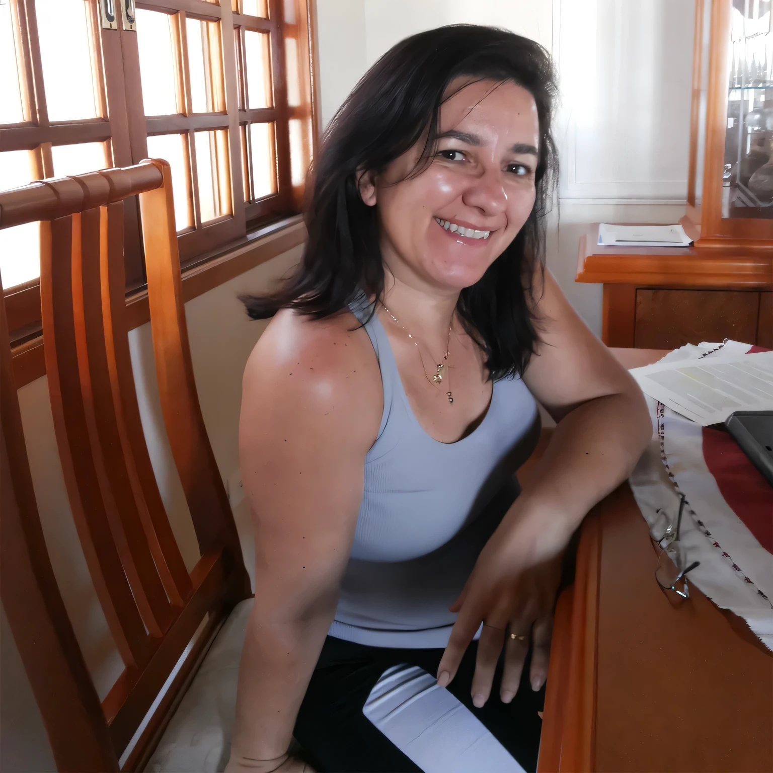 smiling woman sitting at the table with a laptop, 35 years old Brazilian. Woman in good physical shape. A woman with white skin and dark hair. She is about 35 years old. Her slightly plump red lips are like a delicate flower, her dark brown eyes seem to contain a world of wonders. Slim body. Thin waist. Her body exudes glamor and her face is the definition of beauty. Highly realistic, still, slightly full lips, pink lipstick, smile, feeling of lightness and joy, hyper-realism, very elaborate skin, look. Fitness woman. Sharp photo, high quality, high resolution, masterpiece, 8k.