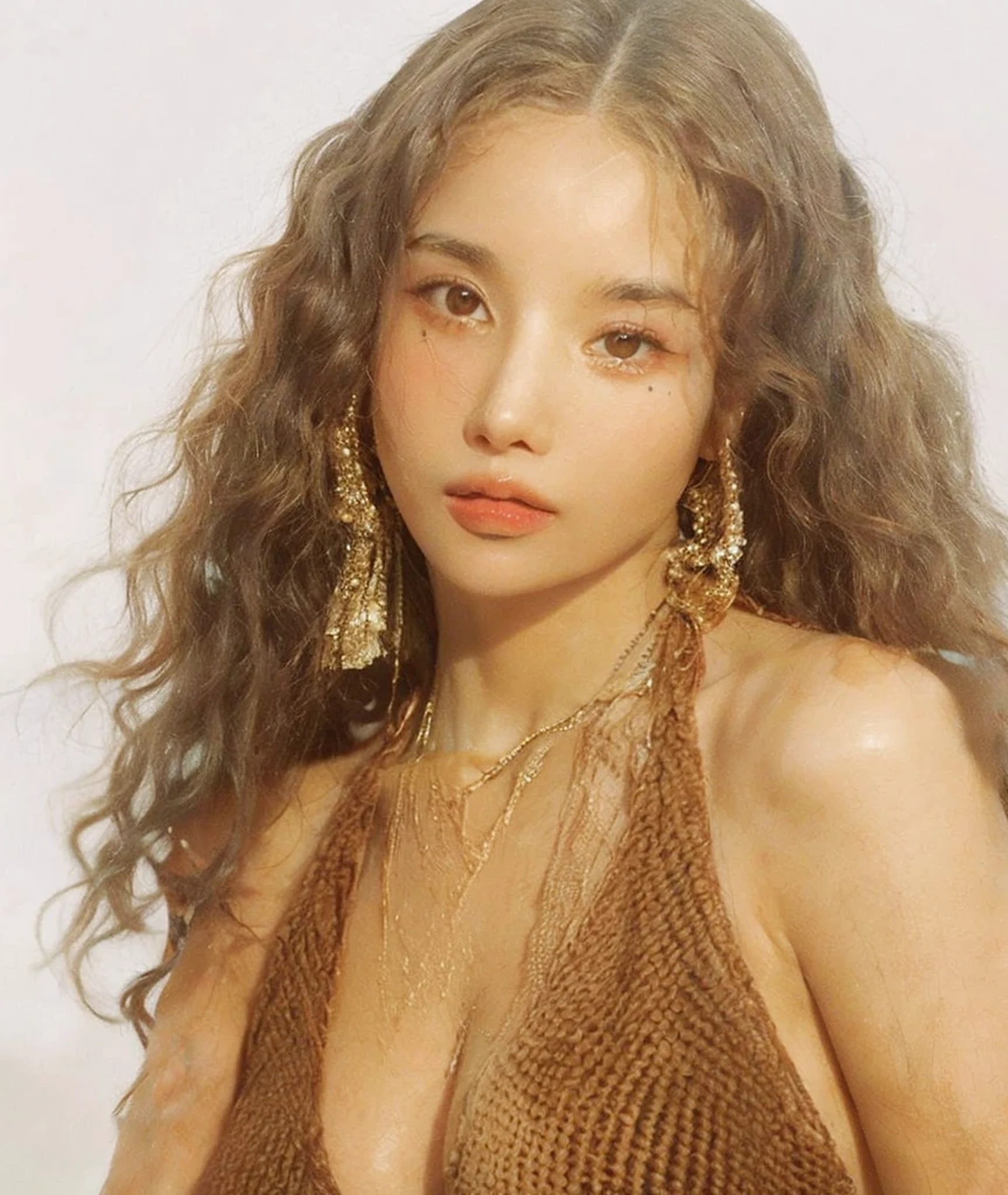 a close-up of a woman with long hair wearing a brown bikini, zoë kravitz, Retrato de Sophie Mudd, taken at the beginning of 2020, imagem vazada, retrato de Vanessa Morgan, ela tem pele morena oliva, photo shoot for glossy magazine, with pale skin, brincos enormes e maquiagem estranha, por Winona Nelson, quanto, Linda Poarca