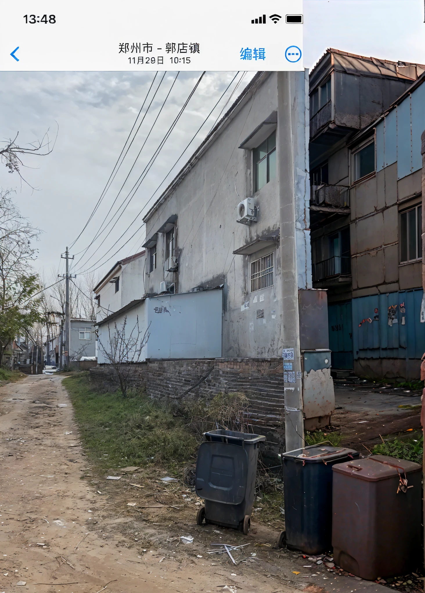 there is a picture oF a street with garbage cans on the side oF it, back alley, ground level view oF soviet town, F / 1. 9 6. 8 1 mm large 4 0, some houses in the background, location oF a dark old house, Big, poor building, poor building, on a street, empty buildings and vegetation, alley