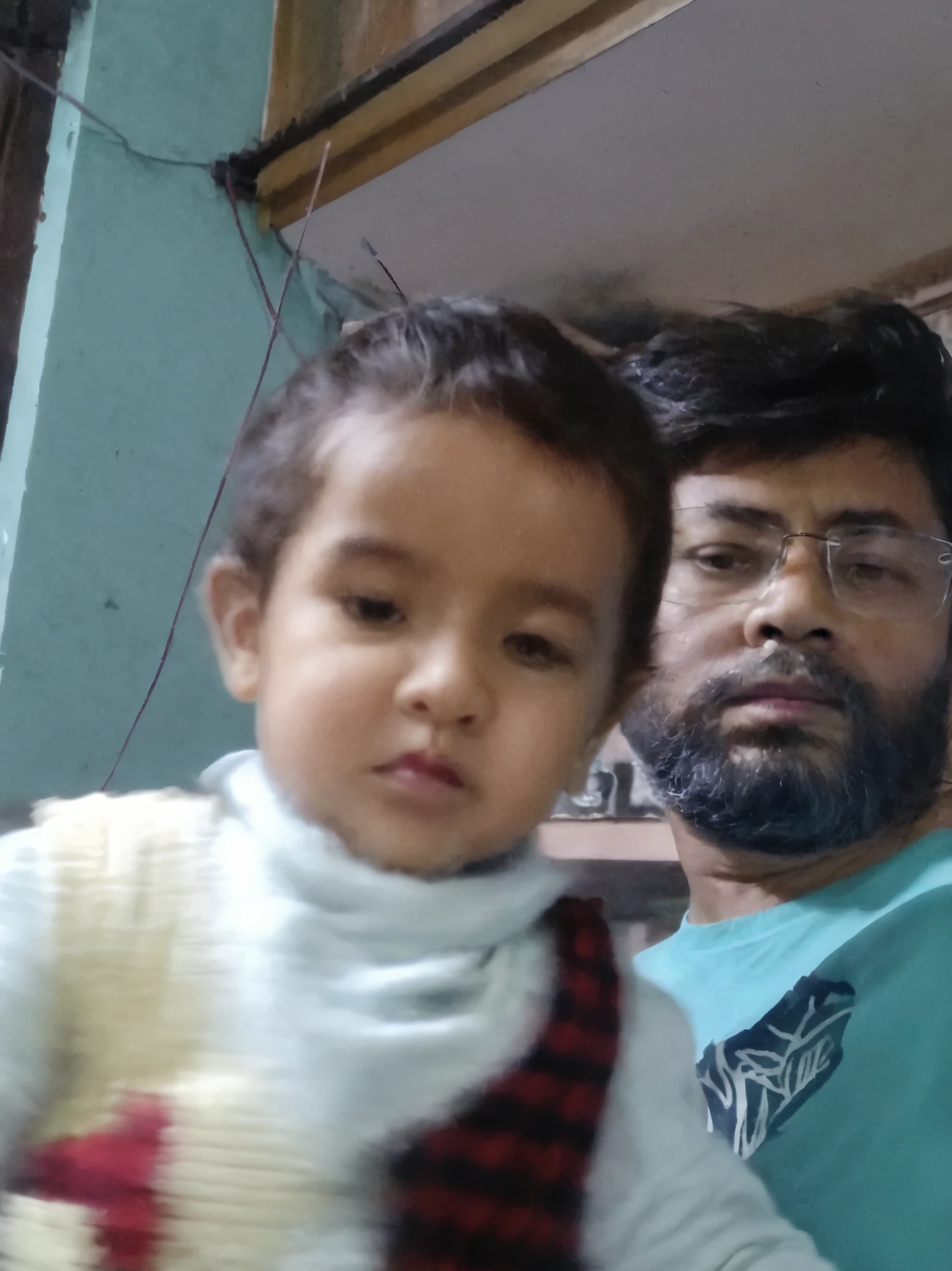 there is a man holding a baby and smiling for the camera, with a kid, father with , 4 0 years old man, very clear picture, very very low quality picture, father, portait image, jayison devadas, about 3 5 years old, ayan nag, old picture, caring fatherly wide forehead, 2 7 years old, 3 2 years old