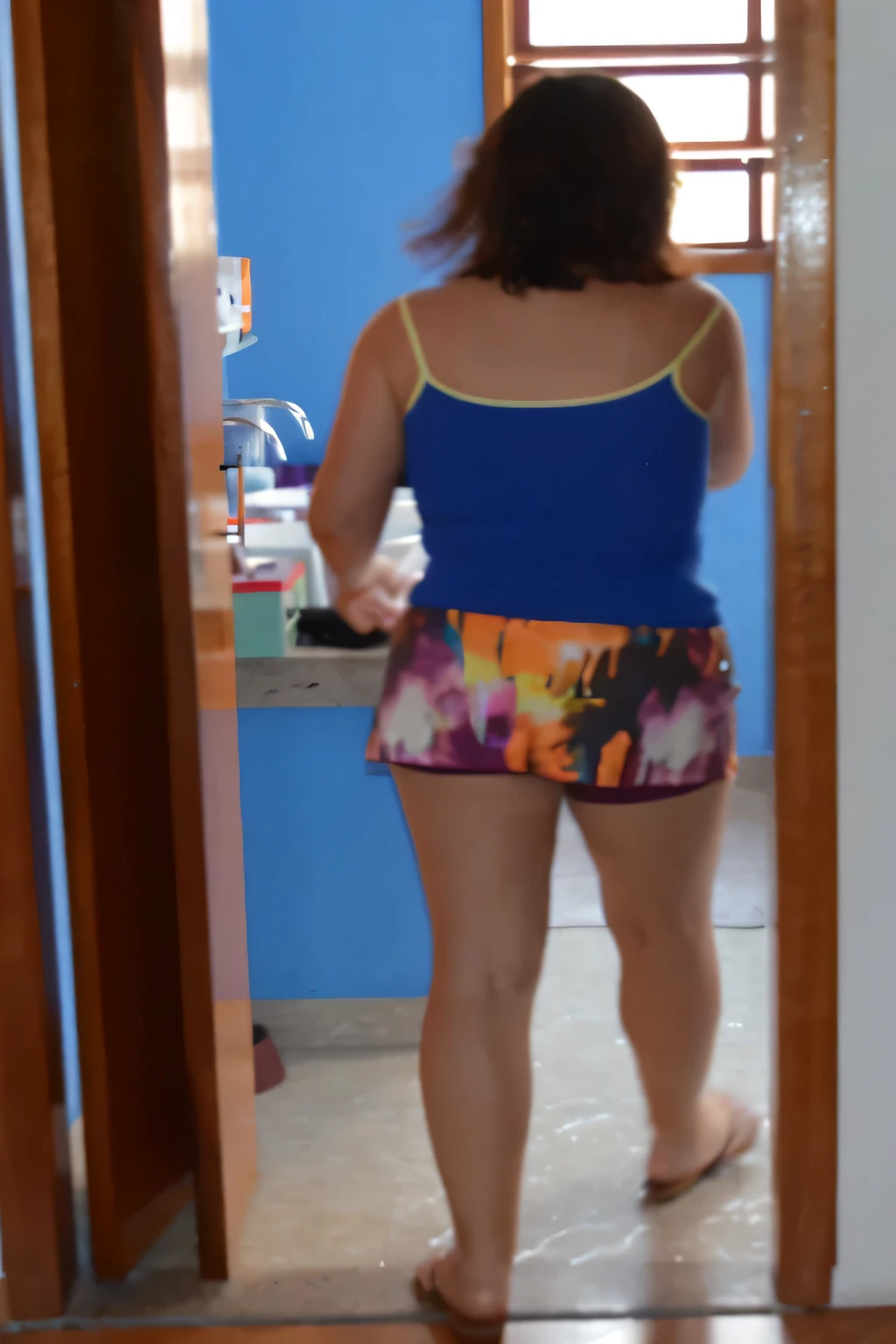 there is a woman standing in a doorway with a blue shirt, wearing a camisole and shorts, in shorts, wearing a tank top and shorts, dressed in a top and shorts, uhd candid photo of dirty, distant full body view, full length view, short shorts, side shot, view from behind mirror, middle shot waist up, colorful outfit