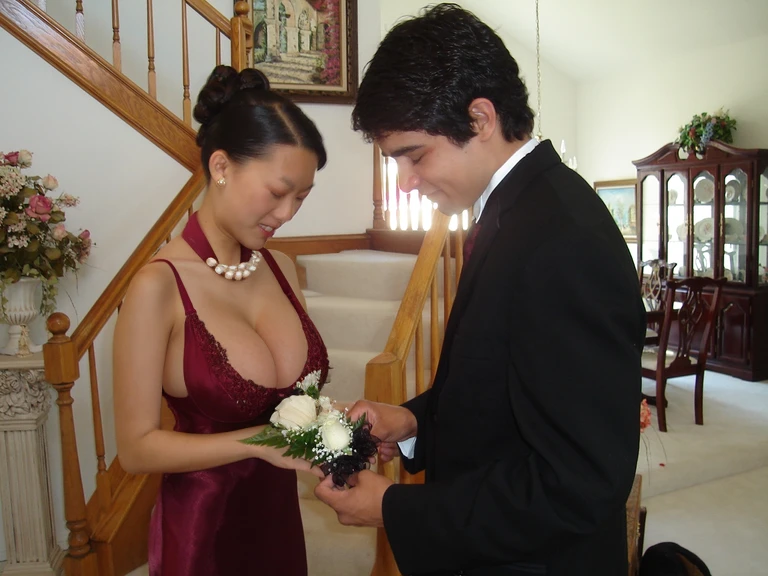 Dslr photo, (8k, 4k, masterpiece), beautiful pretty asian woman, standing with prom date, standing in front of stairs, full body view, standing, smiling, looking down, (huge breasts:1.1), (natural breasts), (cleavage:1.2), dark red dress, corsage, shear straps, pearl necklace