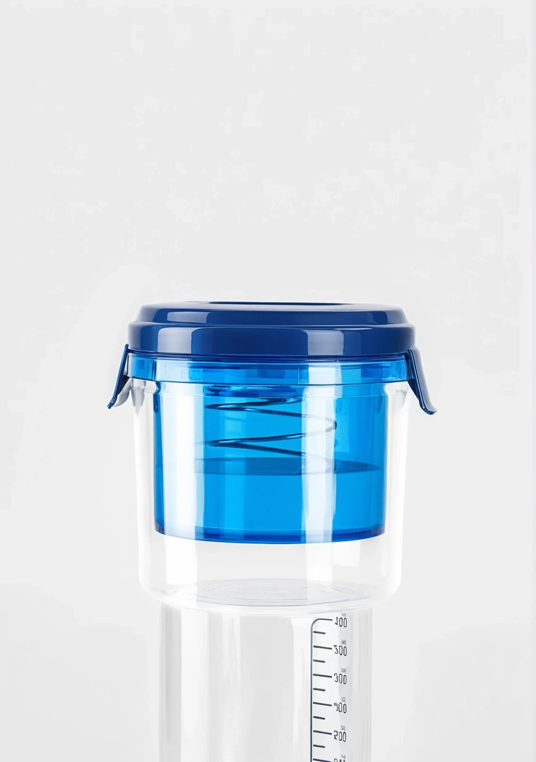 The focal point is a high transparency blue bright plastic container with a perfectly high gloss textured plastic blue lid. The glass is extremely smooth and reflects soft light. It is clean without any stains, showing the purity and high-end of glass products. The plastic cover has a strong glossy texture, and its high-gloss spots accurately reflect ambient light, making its high-quality material easy to identify. Below is a highly transparent and high-quality measure, with the entire background in gray and white tones, enhancing the comfort of home and homemade food.