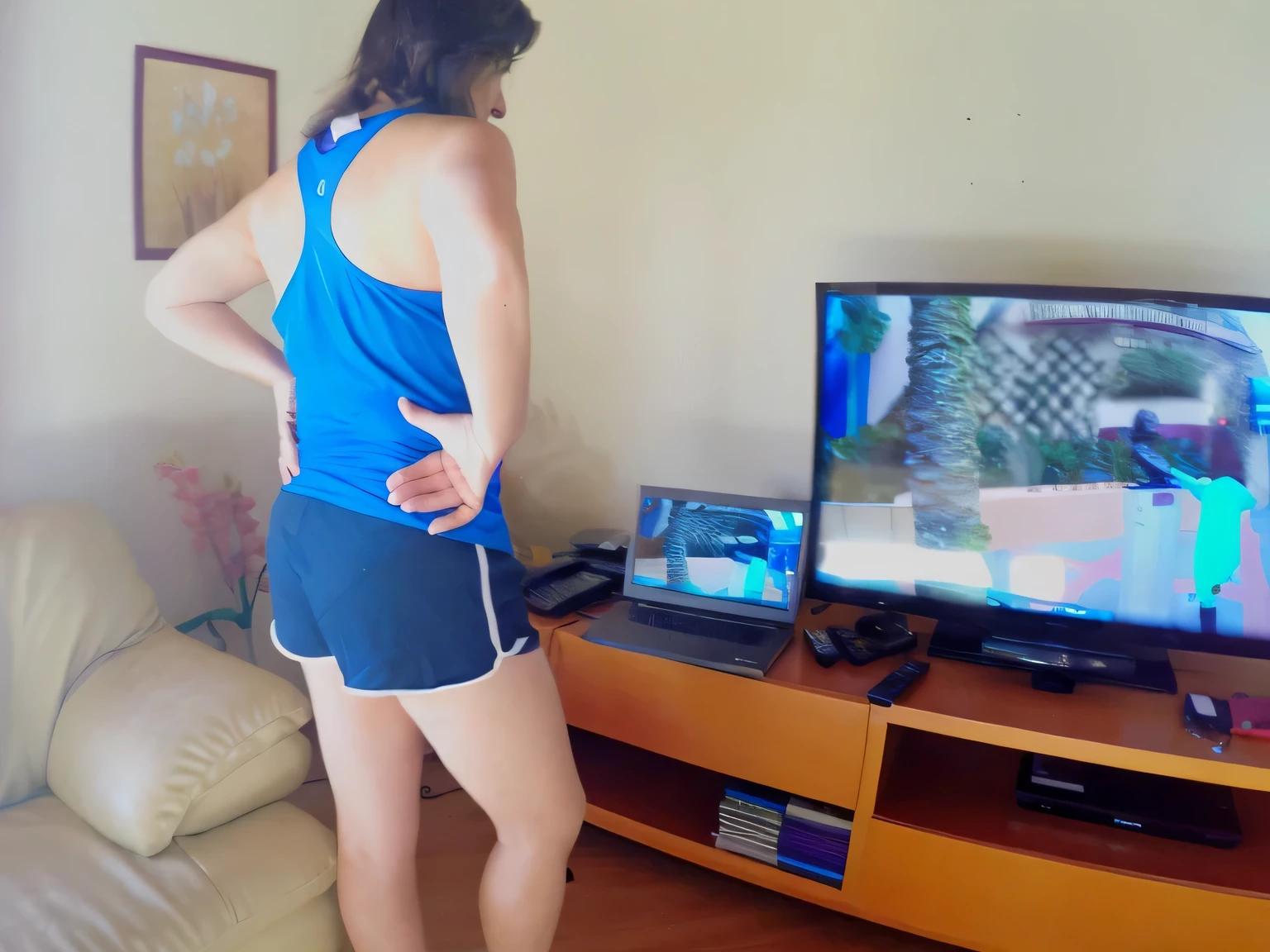 there is a woman standing in front of a television playing video games, back shot, back shot, from the back, back shot, from the back, side shot, rear view!!, full body distant shot, back shot, close up back view, waist shot, back view, back and standing view, back view in front of a television in a living room, short sports shorts and short tight dark blue shorts, wearing blue blouse and short tight shorts , t-shirt and sports shorts, wearing t-shirt and short, tight shorts, tight, short shorts, wearing gym equipment, in short shorts, dressed in tank top, 35 year old Brazilian mother wearing gym equipment, fitness body. Full body photo in high resolution and high quality, 8k.