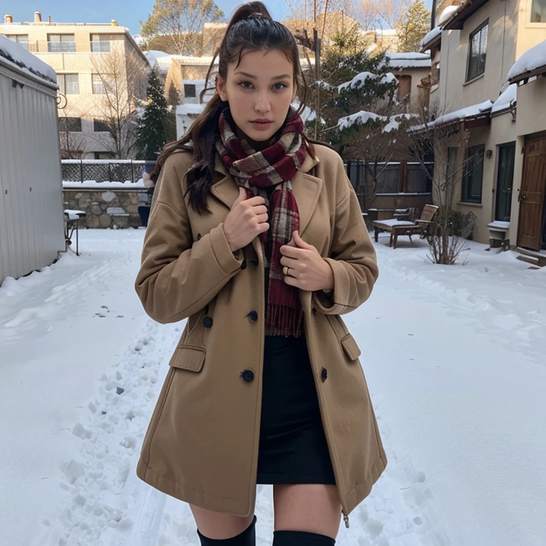 Bella Hadid in the snow wearing a coat and scarf