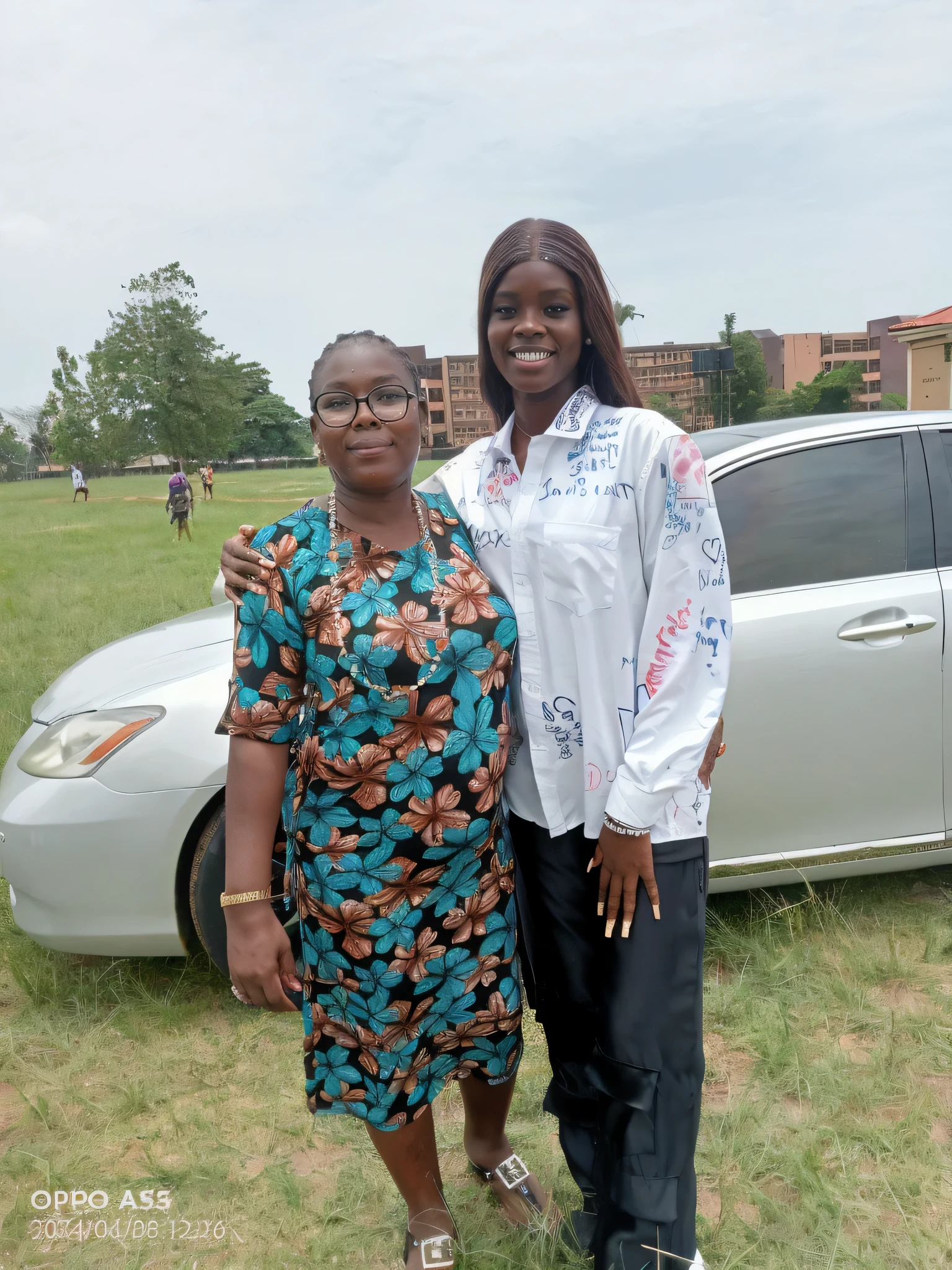 there are two women standing next to a car in a field, 2 0 2 2 photo, digital image, very very low quality picture, by Marshall Arisman, digital photograph, edited, group photo, commissioned, album photo, young lady, high quality picture, student, a picture, by Chinwe Chukwuogo-Roy, discovered photo