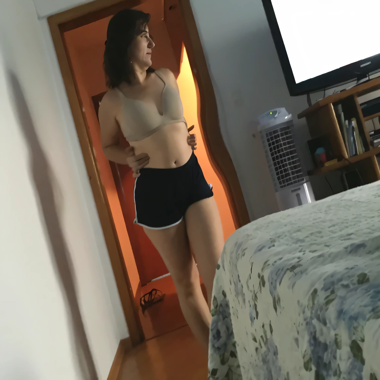 ((Best quality, 8k, Masterpiece: 1.3)), photorealistic, sharp focus, high quality, high resolution, portrait, solo, 40 year old woman, beautiful, 42 years old, wavy hair, beige bra, very short black shorts. there is a woman in a bra top and shorts standing in a room, posing in a room, fiddling with her clothes, without much clothes, in shorts, in her room, sports bra and dark black shorts, extremely hot and sexy, thighs exposed! !!, medium shot from the waist up Fit girl. High quality, high resolution, masterpiece, 8k.