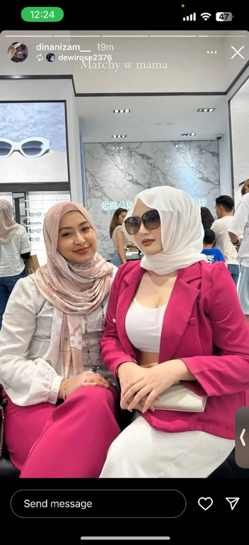 two women sitting next to each other in a room, with sunglass, appearing in a shopping mall, low neck white see through cropped tank top, can see belly button, beautiful figure, big  , sexy cleavage showing from tank top, no undergarments under tank top, seducive