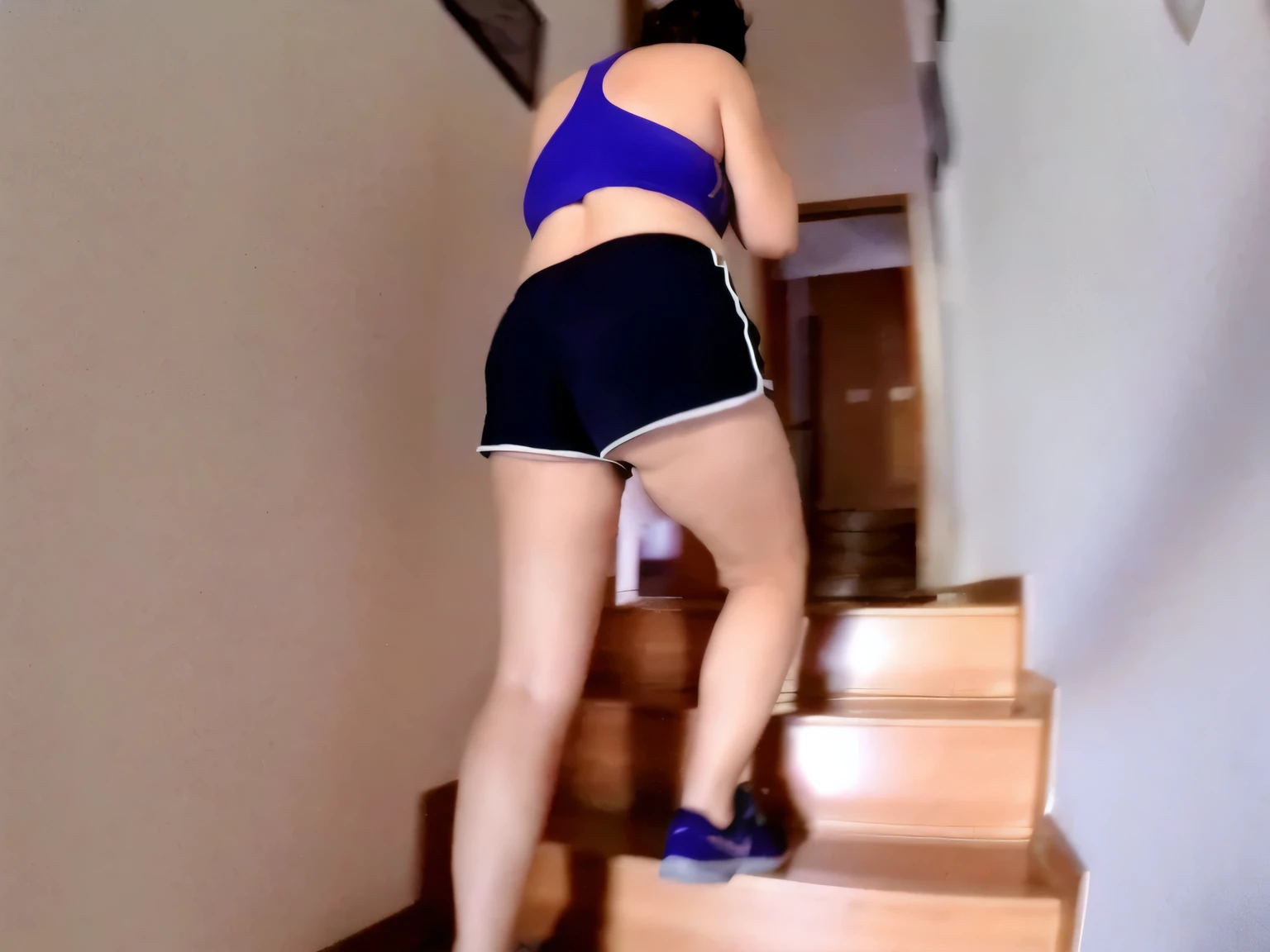 RAW, Best quality, high resolution, Masterpiece: 1.3, Beautiful brunette. Best quality, high resolution. Realistic, detailed and complete woman in a blue top and very short black shorts climbing a flight of stairs, side view of her taking steps, in shorts, working out, exposed thighs!!!, training, stairs, thighs!!!!!!, thighs! !!, cottagecore!! fitness bodysuit, sports bra and dark blue shorts, toned legs. She is around 35 years old, a woman in good physical condition. Masterpiece, best quality, (best quality), realistic lighting, 8k.
