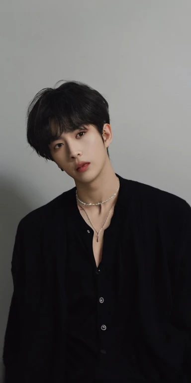 male in black cardigan and black shirt, collar bone, grey wall background, handsome boy\'s plump lips, round face shape, black hair, black korean hairstyle, silver neckclase, iphone lens, detailed, realistic