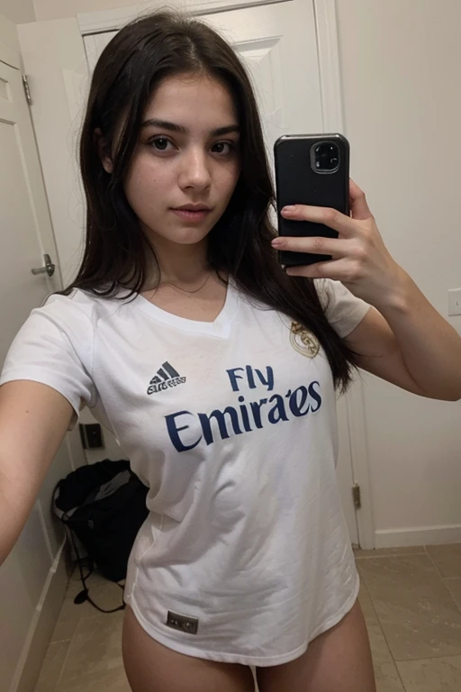 a 13 year old girl with straight black hair wearing a Real Madrid shirt taking a selfie