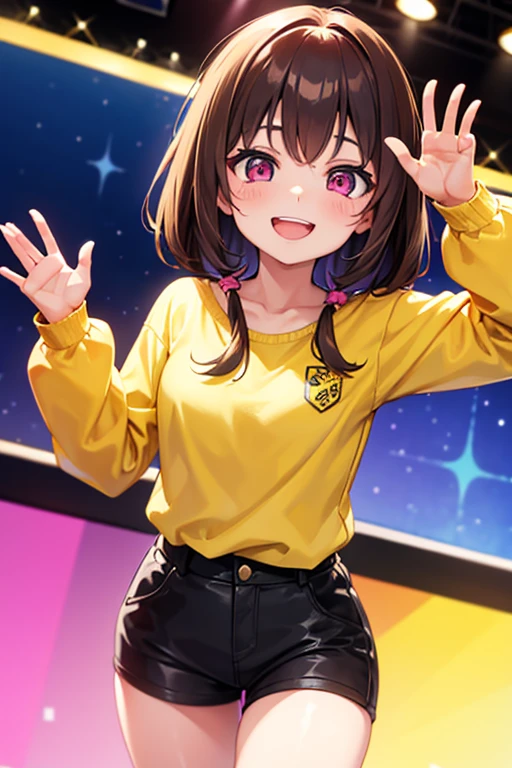 A girl with brown hair and pink eyes wearing a yellow top smiling at the screen waving her left hand