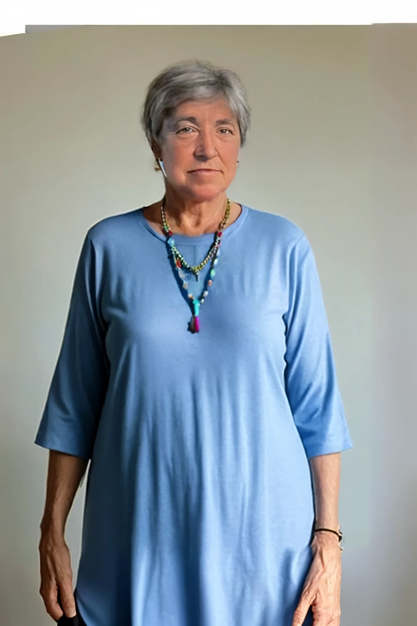 Arafed woman in a blue shirt and necklace stands in front of a wall, Barbara hemp, Louise Dahl - Wulf, Diana Levin, Nancy Grossman, Suzanne Engelberg, Barbara Hammer, portrait in clothes, no nudity, Ann Long, Lynn Skordahl, Yulia Gorokhova, Yoko of Golbachie, author zima blue