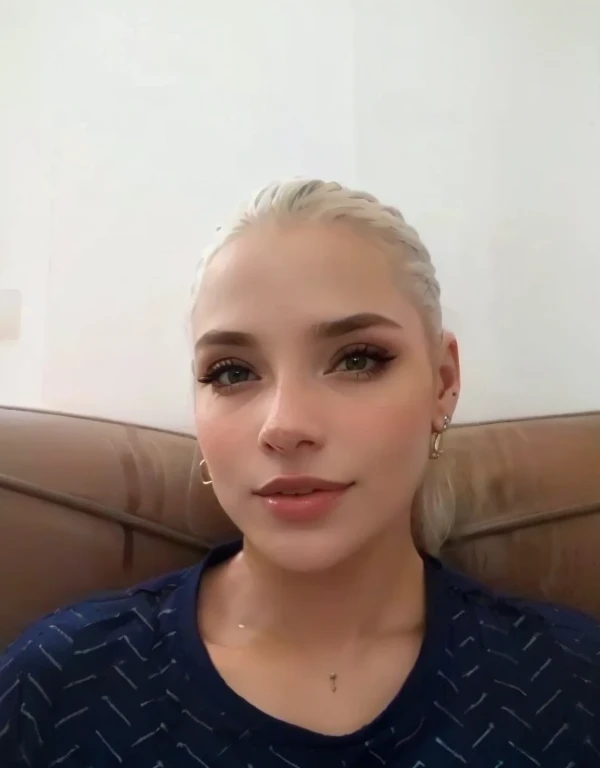 mulher loira com camisa azul e brincos, e seios enormes  olhos azuis e batom vermelho 