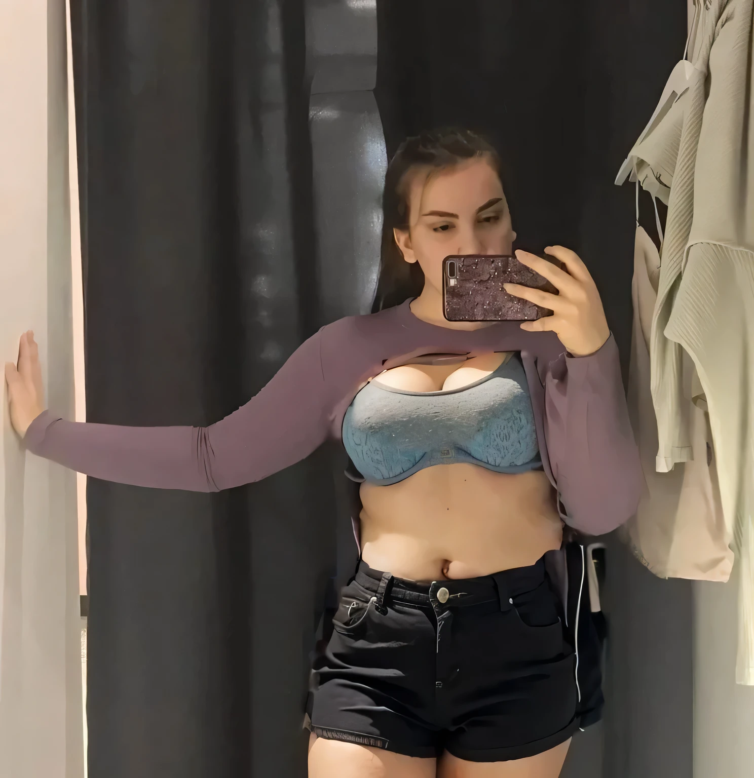 A girl stands in a fitting room with her jacket lifted above her chest, the jacket is pulled up over the chest in folds, the jacket is rolled up with folds, a girl with wide hips stands without pants, the girl is not wearing pants, the girl is not wearing shorts, girl with wide hips stands in shorts, the girl is wearing underwear