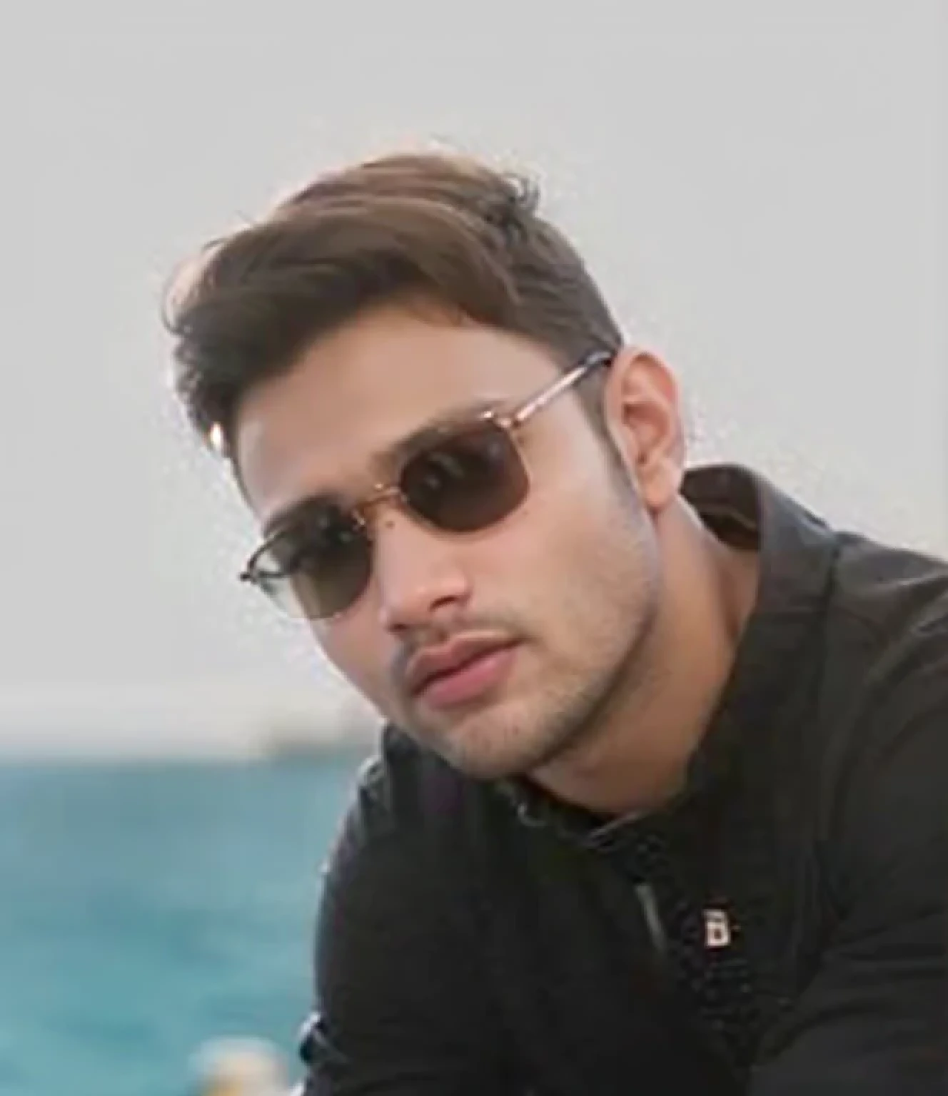 A beautiful young bearded man with highly detailed skin looking at the camera,8k,high res, soft light,no contrast,ultra realistic, photorealism.((real life photo,realistic:1.9, short beard:1)),(wearing black sherwani),((closeup shot:1.5))
