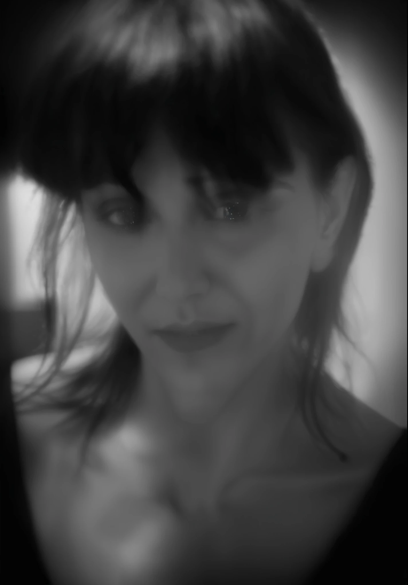 a close up of a woman with a black shirt and a black background, grainy photo of an ugly woman, inspired by Kati Horna, eerie self - portrait, blurry face, blurry image, blurry photo, grainy monochrome photo, not blurry, very grainy image, grainy black-and-white photo, grainy low quality photograph