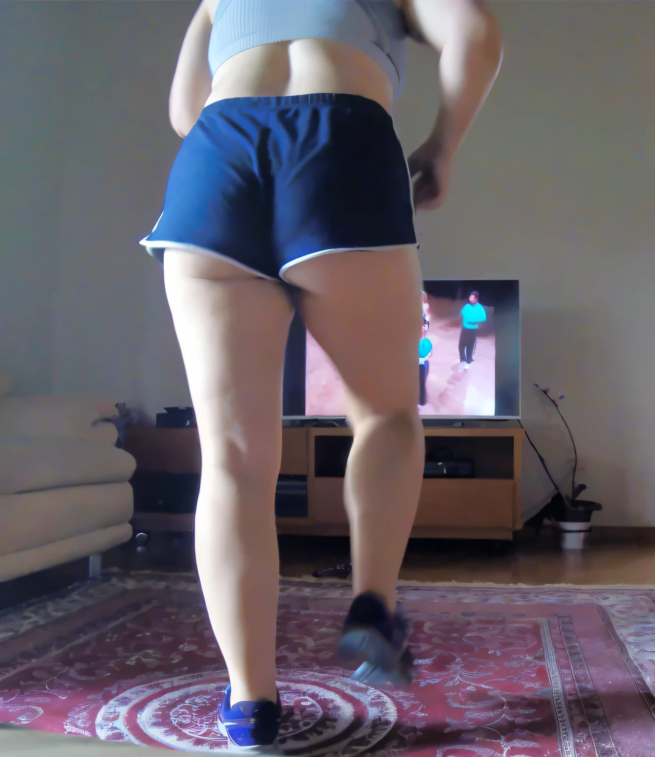 there is a woman standing on a rug in front of a television, in shorts, thighs!!!, thighs!!!!!!, bare thighs!!!, exposed thighs!!!, long shot from the back, long shot from back, lunging at camera :4, picture from behind, toned derriere, view from the back, thighs focus, walking away from camera