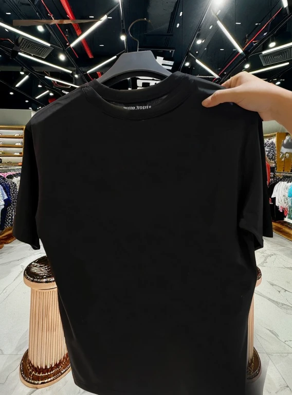 A person is holding a black shirt in the store with a black hanger., black t-shirt, black shirt, Black long sleeve shirt, black t-shirt, Wear a black shirt., สวมblack t-shirt., สวมblack t-shirt., short sleeve, เขาสวมblack t-shirt., black casual clothes, Gucci clothes, black top, Wear a black shirt.