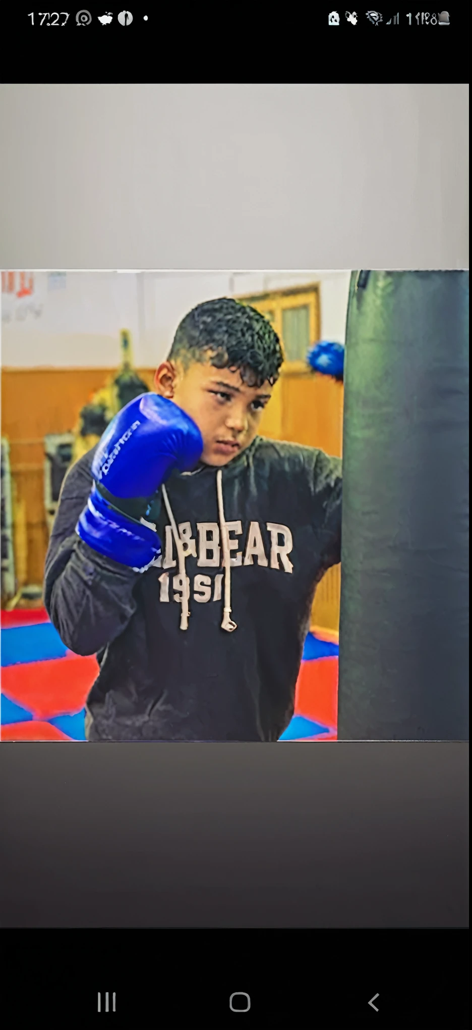 Close-up of a person wearing boxing gloves near a punching bag, mohamed chahin, In the boxing ring, In a fighting stance, Amazigh boy, Ikot Idodo, Juan Diaz channels, khyzyl saleem, Gama Gourabaev, Andres Rios, Saadane AFIF, david marquez