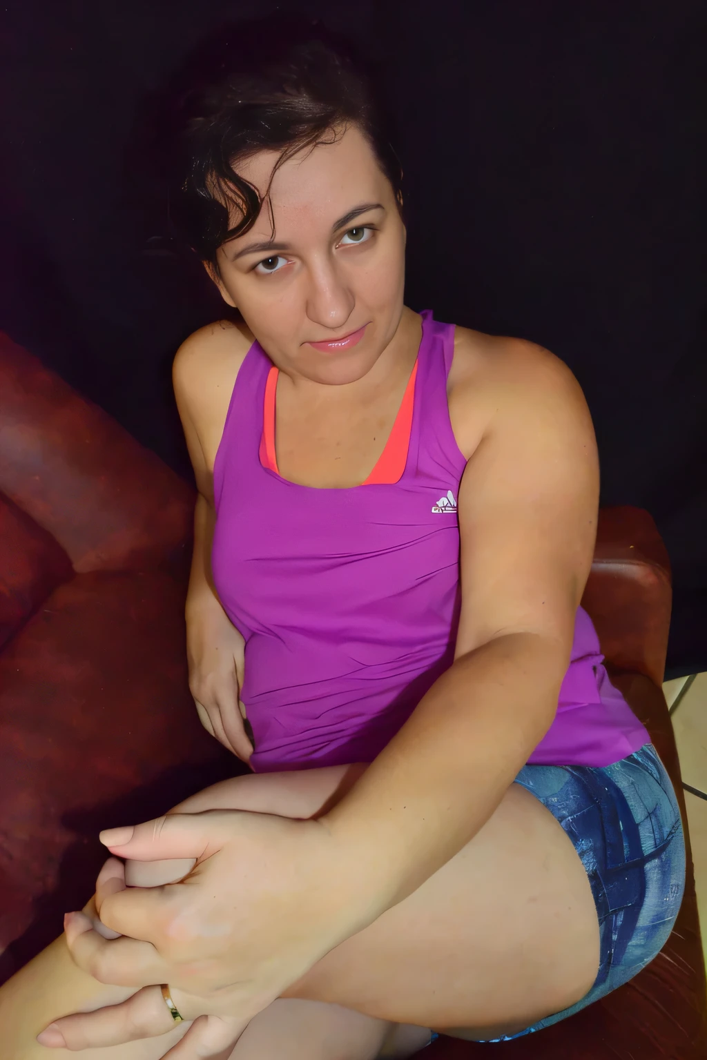 Light brunette woman in a purple top and blue shorts sitting in an armchair with her legs crossed, sitting on bent knees, half-length photo, half-body close-up, seductive sitting pose, leg and hip photo, side portrait, back photo, big thighs, beautiful woman with perfect body, doing sassy pose, 40 year old woman, full body sarcastic pose, photo shoot, lewd pose. Shapely woman in purple top and blue shorts posing for a photo, arms to the side, violet tight top, half body close up, full body portrait photo, full body, full body photography, centered full body photo, woman 40 years old, 4k, portrait photo, light violet tank top, profile photo, sweaty face, 3/4 solo portrait, suitable photo, black background. She is wearing a vibrant pink-purple sports tank top and mixed shorts (((blue-gray-green-black))), suggesting an active lifestyle or athletic attire for working out. Sharp photo, high quality, high resolution (ultra quality masterpiece), Ultra HD, high contrast, 16K. Masterpiece: 1.3, high resolution, (photographically realistic), NUDE, NUDITY, NFSW.