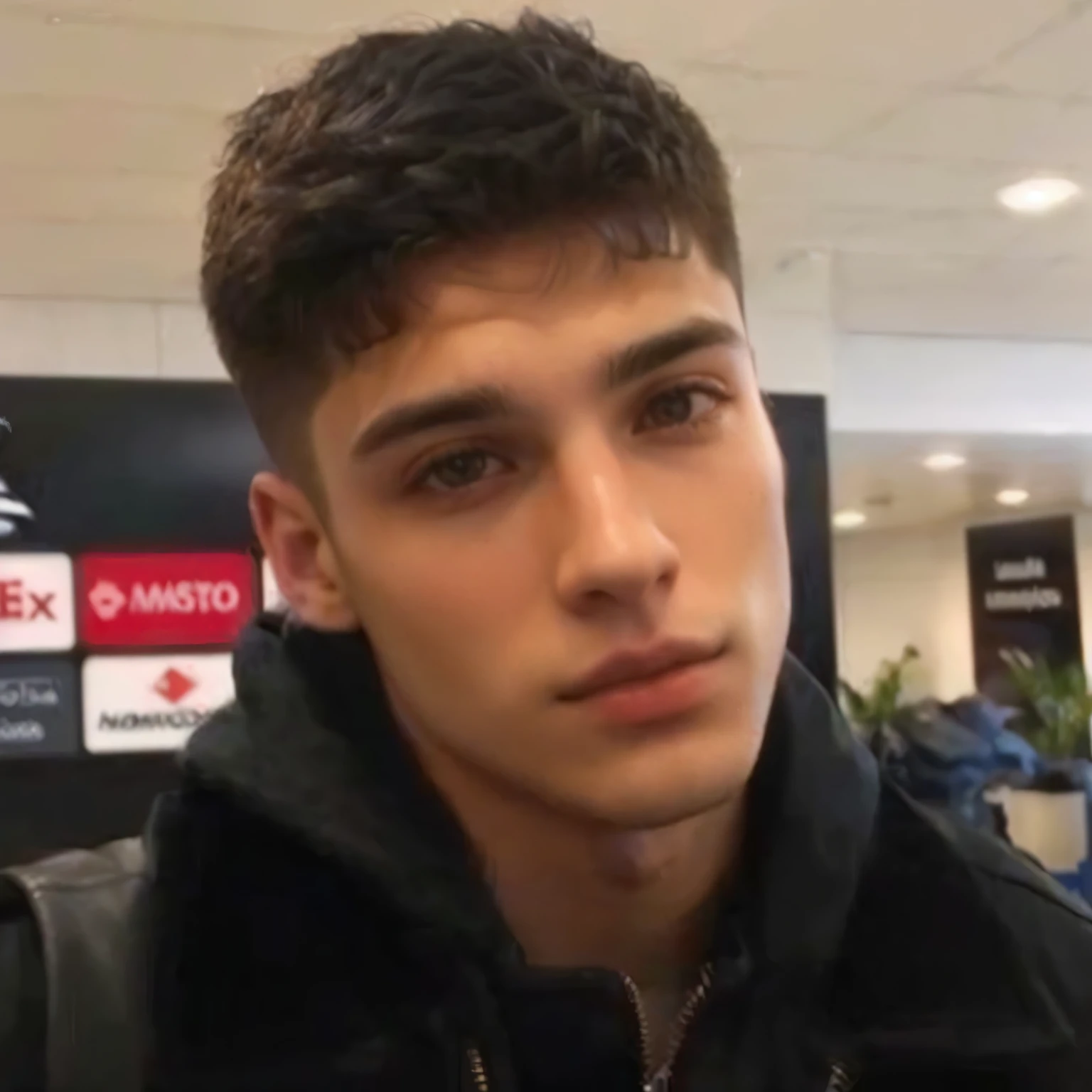 homem arafiado com uma jaqueta preta e uma mochila em um aeroporto, jovem espanhol, short hair on top of head, limpo, barbeado, rosto largo, largo, diego fernandez, rosto largo barbeado e limpo, Damian Kryzwonos, cara muito bonita!!, David Marquez, milhas johnstone, mateus 9 5, Tommy 1 6 anos, jungkook