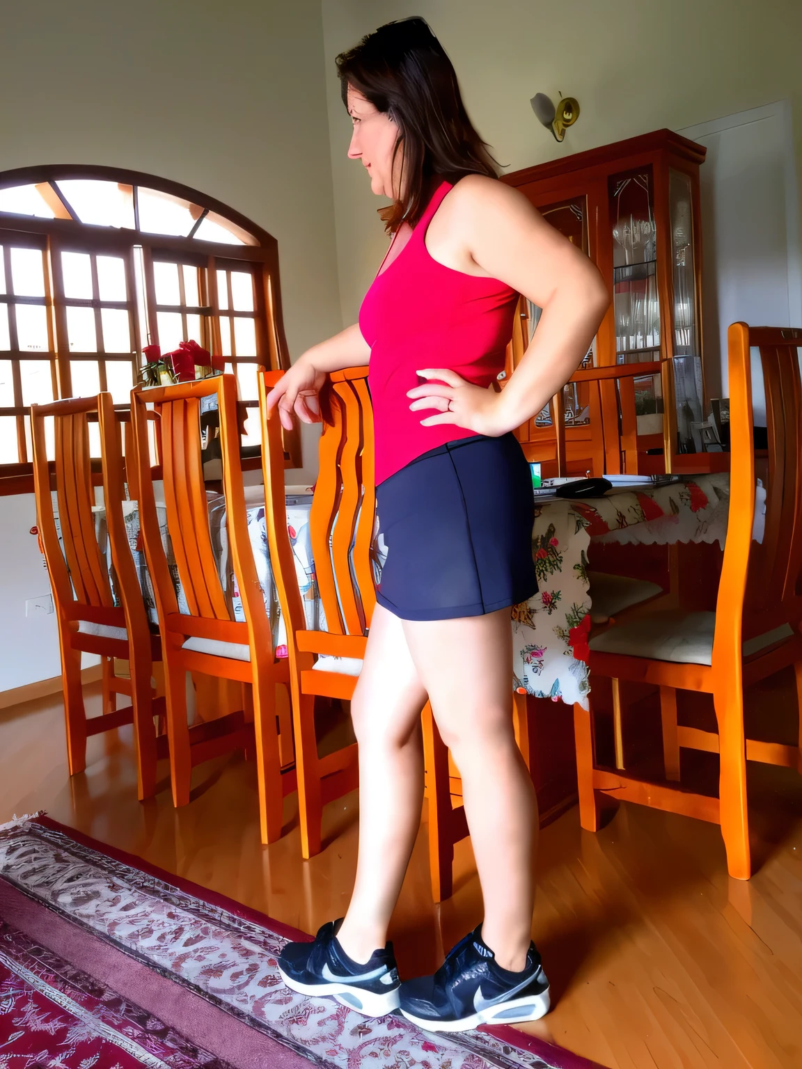 there is a woman standing on a rug in a room, side shot, side pose, side portrait, wearing red shorts, in shorts, side view of her taking steps, sport bra and dark blue shorts, short robust woman, full length view, side profile shot, lunging at camera :4, posed in profile, from side, middle shot waist up
