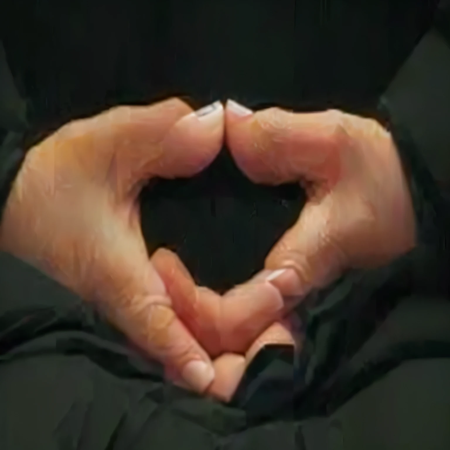 quelqu'un fait un cœur avec ses mains sur une couverture noire, Anjali Mudra, solemn geste, hand geste, mains protégeant le visage, Sukhasana, hands clenched l'une contre l'autre en arc, heavy geste style closeup, symmetrical hands, geste, the forefoot to make a v geste, Closed hands, Blessing of the hands, bosse en forme de main