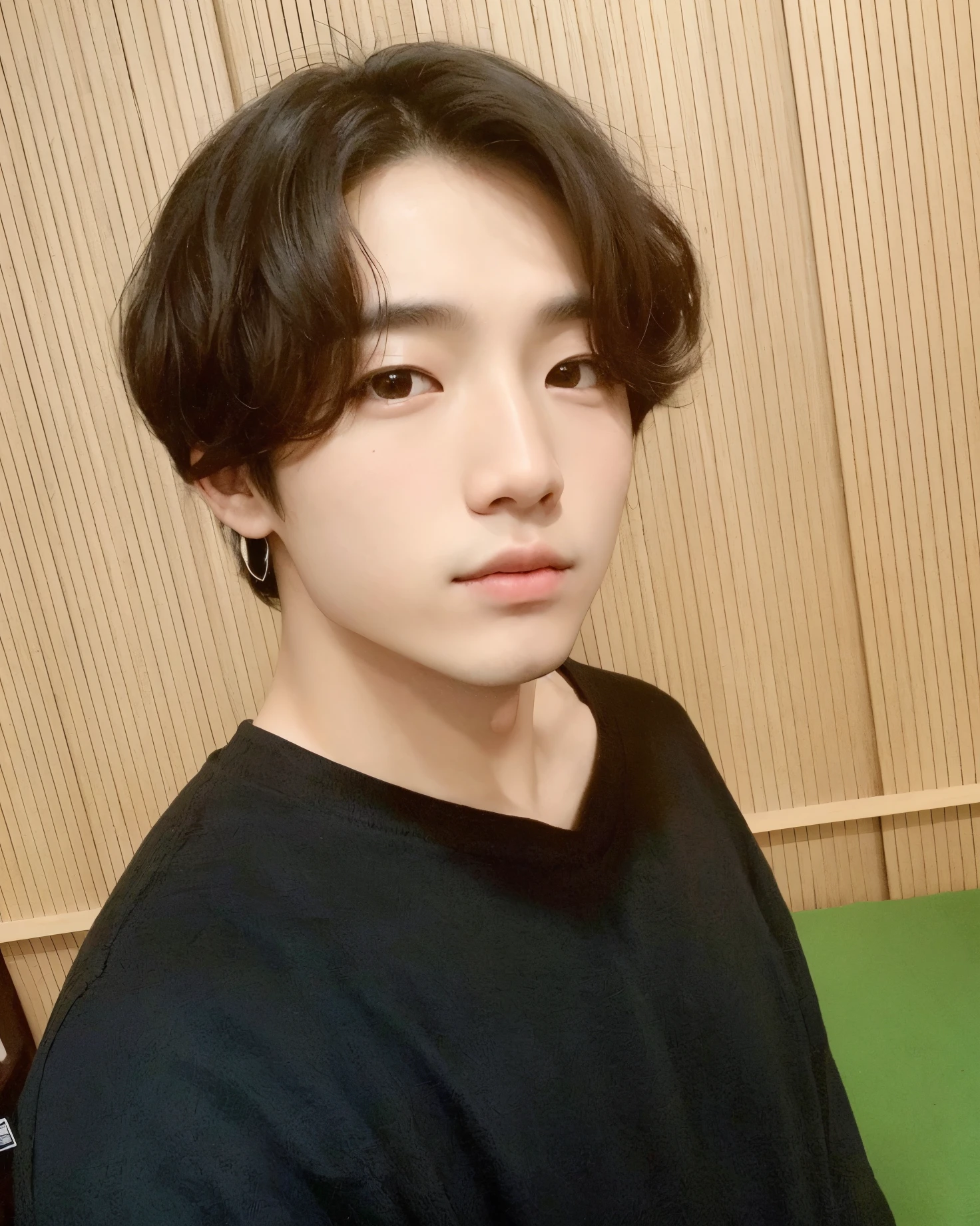 Hay un hombre que posa para una foto, camiseta negra , joven coreano, joven y adorable rostro coreano, Young cute pale asian face, preciosa cara delicada, hombre sin bello facial, hombre con mirada seductora