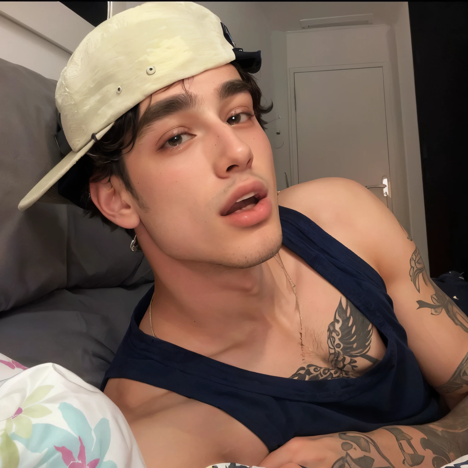 There is a man with a hat lying on a bed, taken at the beginning of 2020, Tommy 1 6 anos, ele tem cerca de 20 anos, ele tem cerca de 2 0 anos, tongue out, o extremamente quente e sexy, 18 anos de idade, inspirado em Randy Vargas, queixo enorme, foto de perfil
