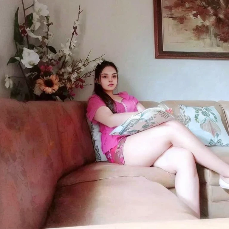 there is a woman sitting on a couch with a book, she is about 20 years old, she is about 2 0 years old, she is about 30 years old, she is about 3 0 years old, she is about 2 , 18 years old, with beautiful exotic, pretty face with arms and legs, young and cute girl