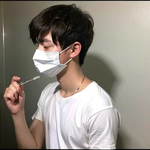 Handsome10A boy about 18 years old has an infectious disease and looks distressed. He is wearing a white mask. He has a high fever. He is sleeping. He is coughing. He is feeling exhausted. His temperature is being measured with a thermometer.