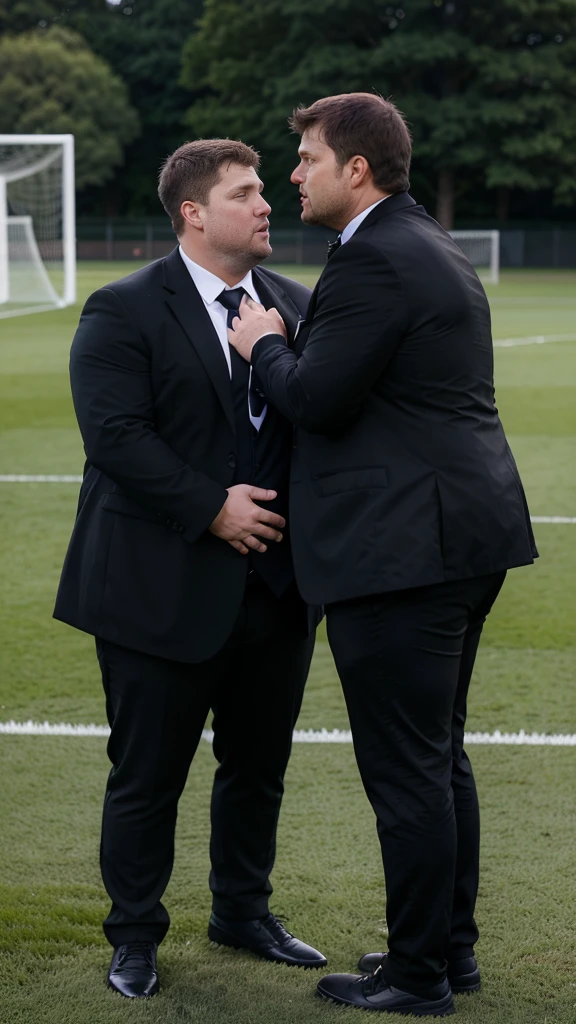 Steven Gerrard and Mauricio Pochettino with big fat round bellies, overwight, fat, chubby, round belly, double chin, (wearing shirt and tie, black coats, tight black suit pants), standing on a soccer field, kissing each other, bellies touching, candid photo, high quality