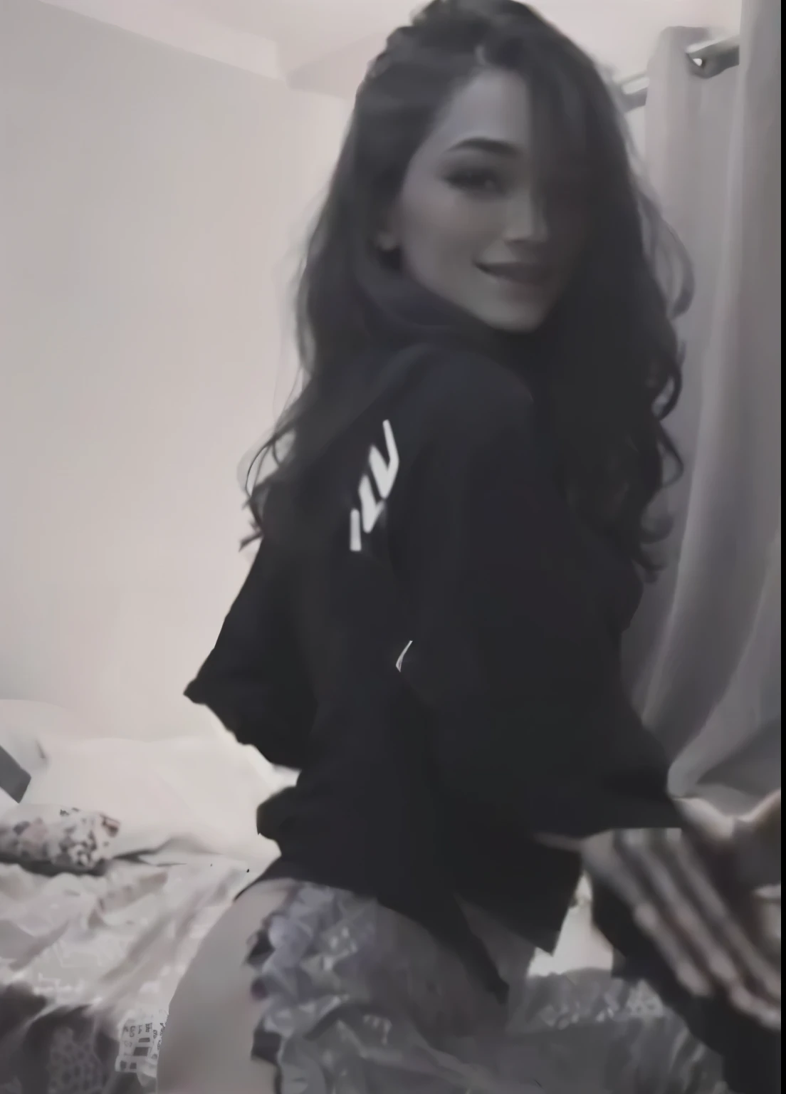 there is a woman that is sitting on a bed with a black shirt, she is dancing, as though she is dancing, old footage, dancing in the background, she is dancing. realistic, low quality video, smiling and dancing, grainy footage, tiktok video, leaked footage, she expressing joy, low quality footage, doing a sassy pose, she is posing