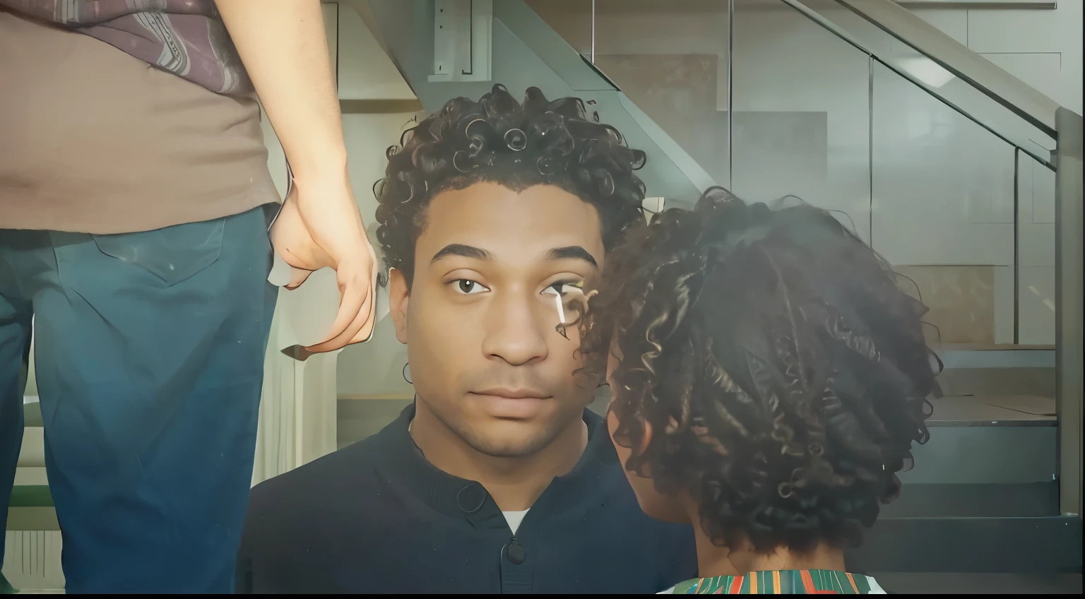 Imagine a scene where father & daughter are sharing a moment. The foreground features a person with curly afro hair, dressed in a green sweater adorned with a festive red pattern. They stand with their back to the viewer, facing towards the second individual. This second person is in the background, their face not visible, adding a layer of privacy to the interaction. The setting hints at an indoor environment, possibly near a staircase, as suggested by the presence of stair railings to the right. The overall mood is intimate, with a focus on the connection between the two characters.