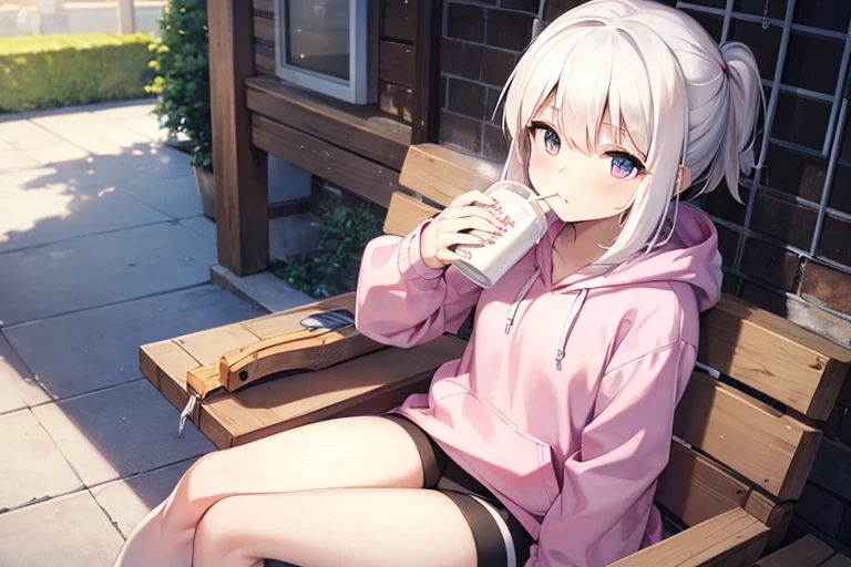 A white-haired girl wearing a pink hoodie is sitting while drinking a box of milk