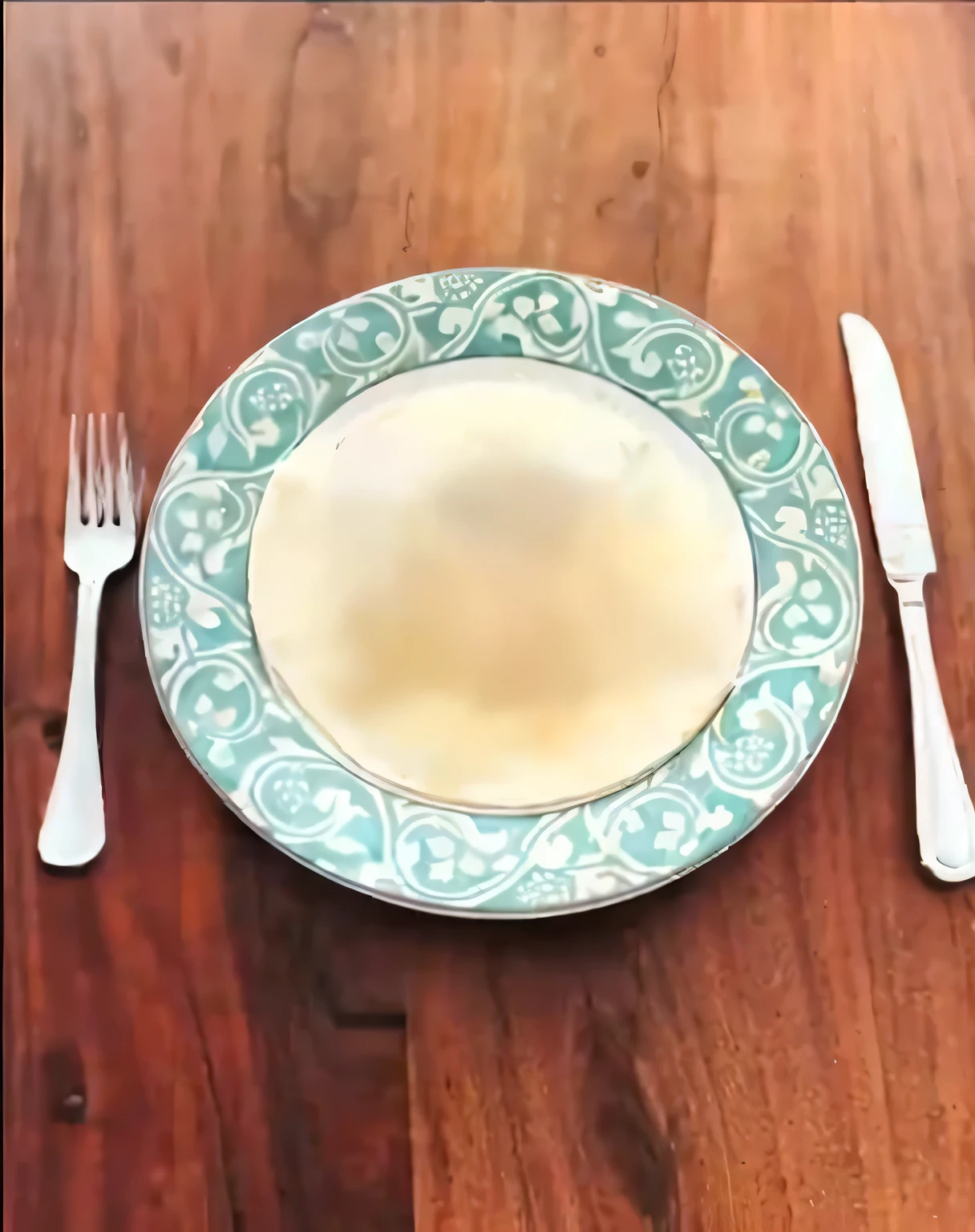 there is a plate with a white substance on it and a fork and knife, served on a plate, on a plate, the plate is on a wooden table, plate, on a wooden plate, plate, full plate, Spoon, the fork is on a plate, [ top view of table ]!!, over a plate and over a table, Eat camera angle