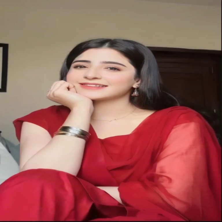 a close up of a woman in a red dress sitting on a bed, maya ali as d&d mage, traditional beauty, wearing a red outfit, very attractive and beautiful, youtube video screenshot, kyza saleem, very extremely beautiful, mahira khan as a mage, tiktok video, maya ali as d&d sorcerer, wearing red attire.ultra HD.high resolusi