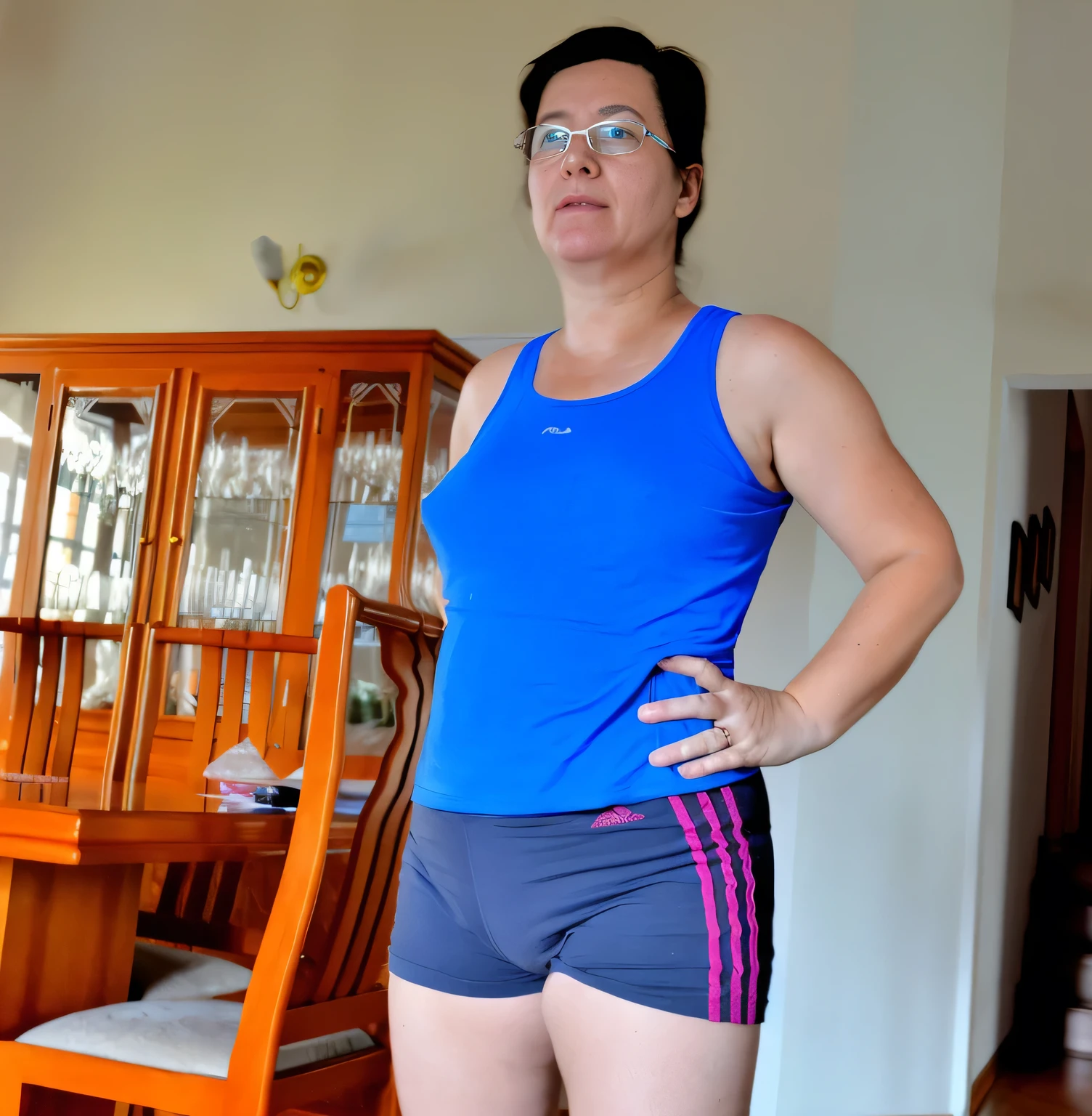 woman in blue tank top and shorts standing in front of a dining room table, sport bra and dark blue shorts, sport bra and shorts, short robust woman, wearing a tank top and shorts, wearing a camisole and shorts, tight black tank top and shorts, wearing fitness gear, dressed in a top and shorts, middle shot waist up, wearing adidas clothing