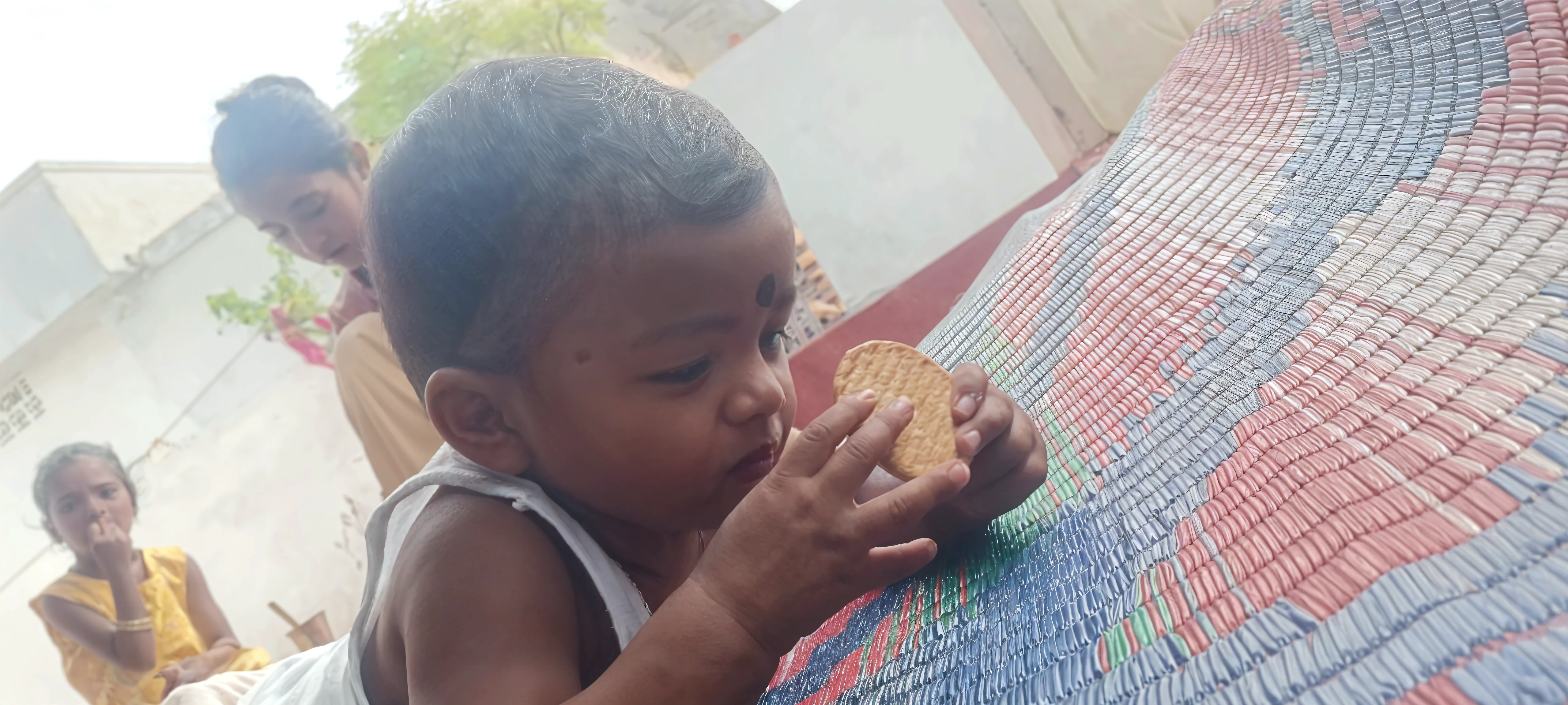 hyper realistic South Indian Father and mother sitting in the fool and their little ??? sit in father's thighs and father write litters in grains ina plate with ??? finger --auto --s2