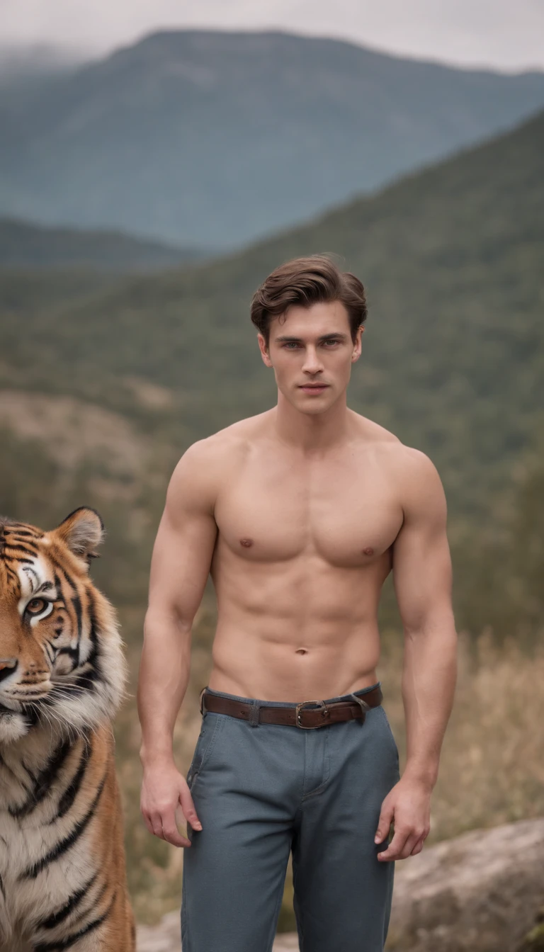 A handsome, burly young man from England without clothes, only wearing trousers, jeans, stands with a large tiger while looking at the camera with a mountainous background.